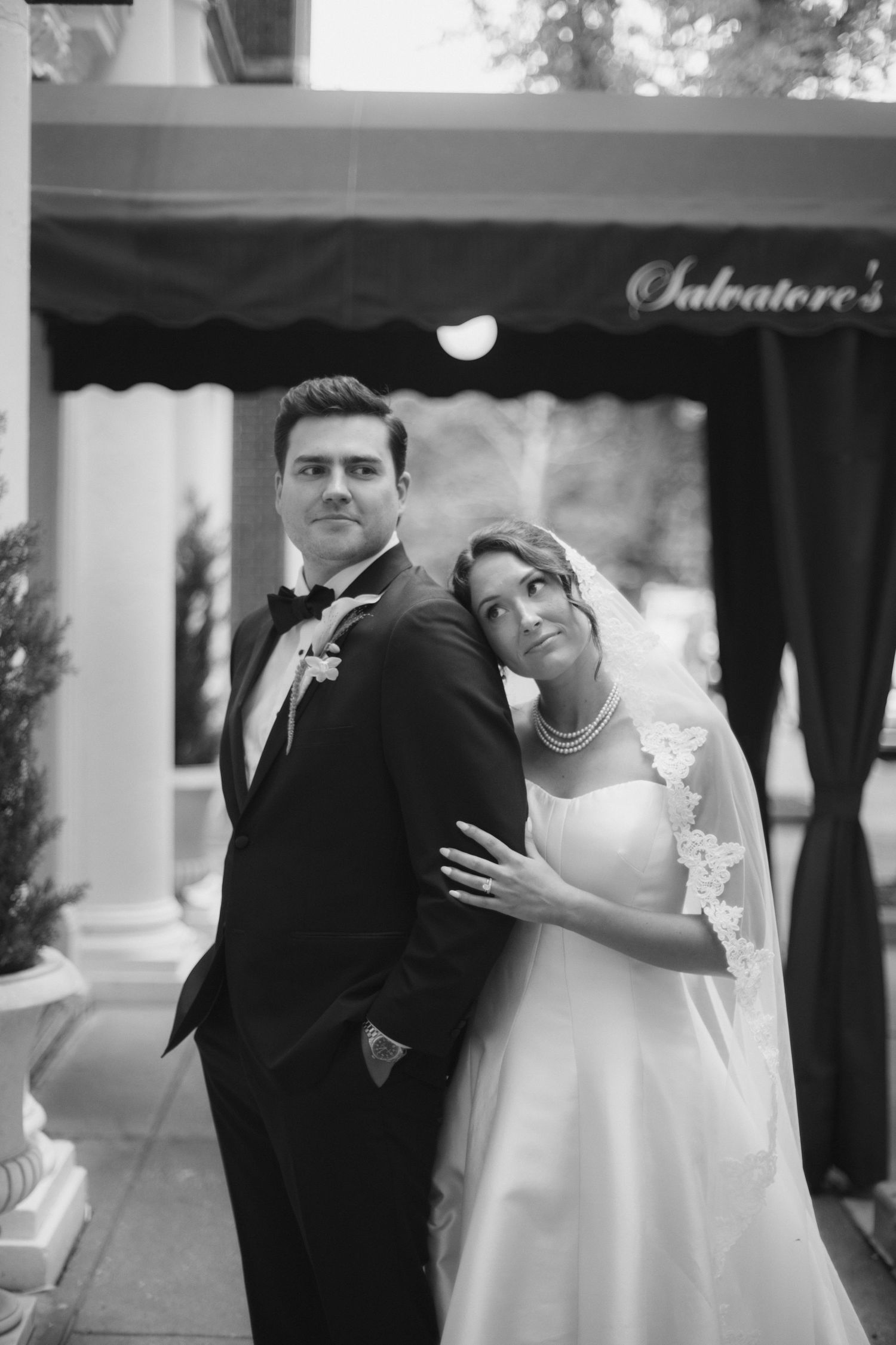 Bride and groom posing in black and white portrait outside Salvatore's.