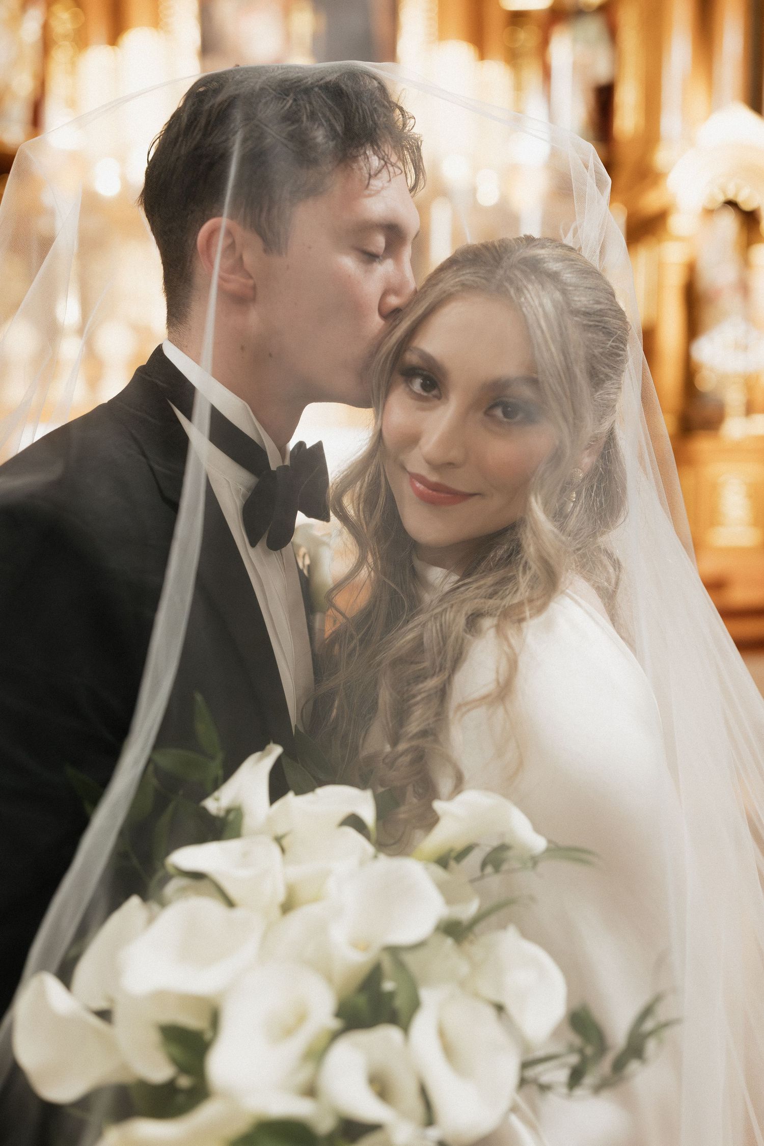 Romantic wedding portraits with white calla lily bouquet and soft lighting.