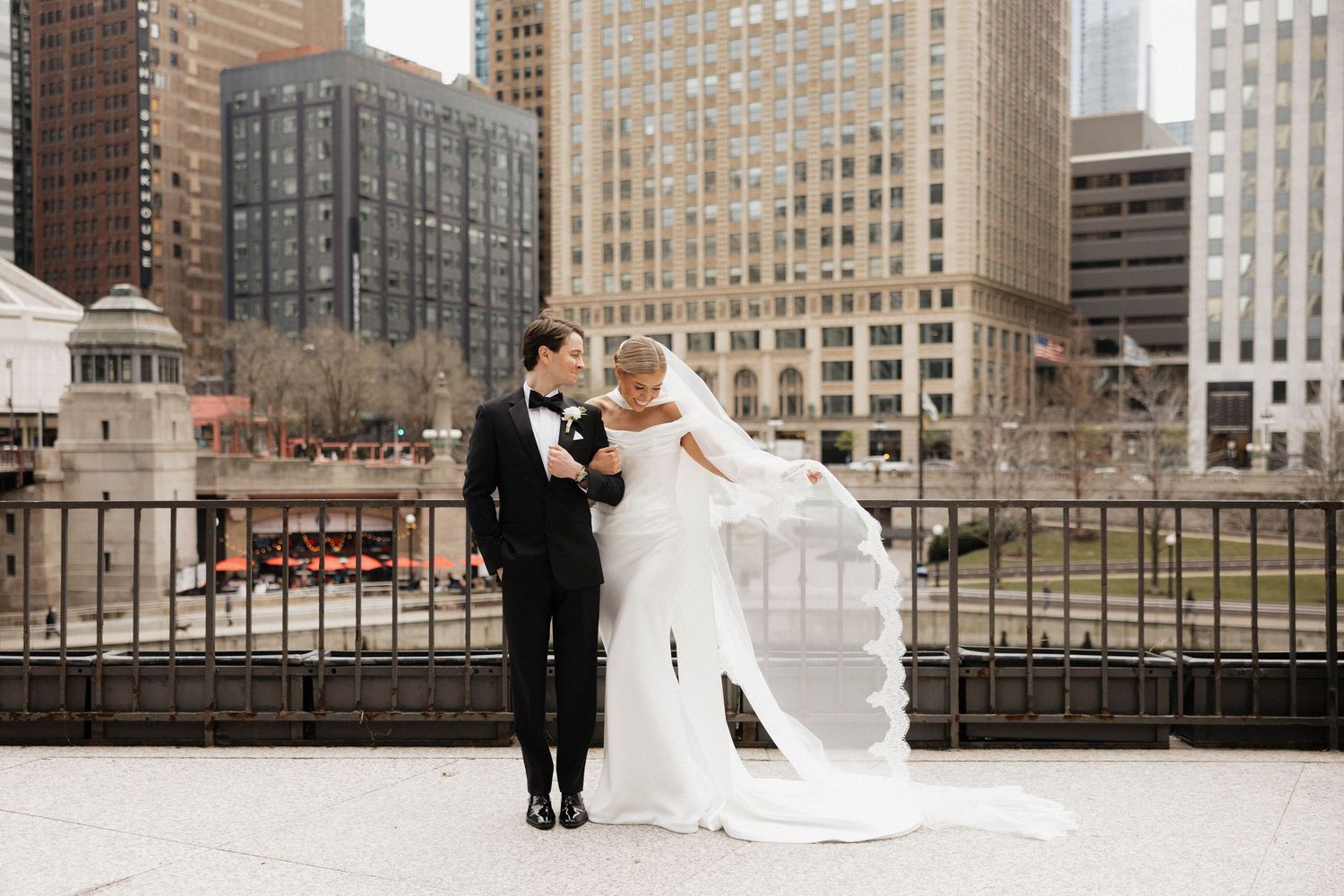 Bride and groom share a romantic moment on a rooftop with Chicago city skyline backdrop.