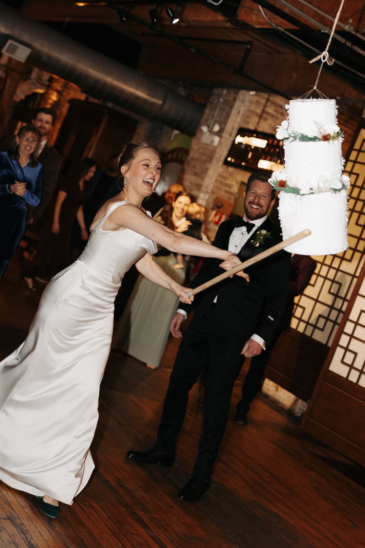 Wedding reception sequence showing joyful dancing and celebration on a rustic wooden floor.