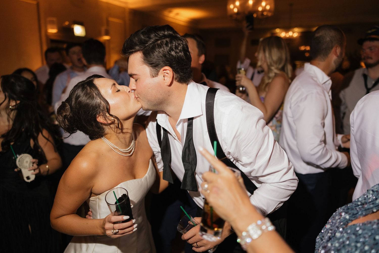 Bride and groom sharing a romantic kiss on the dance floor during their wedding reception.