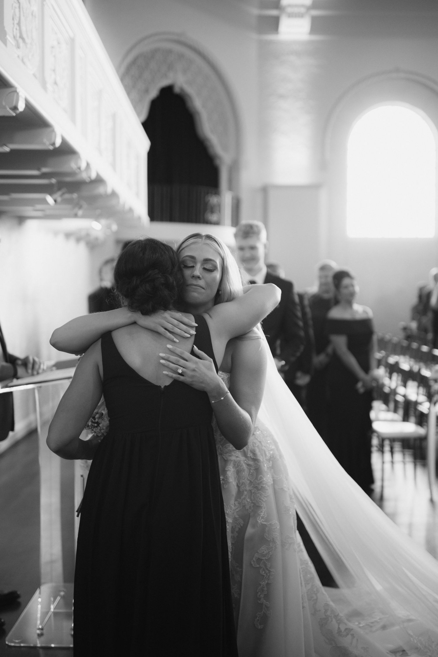 A touching sequence of black and white photos showing an emotional embrace between two people at an elegant wedding venue.