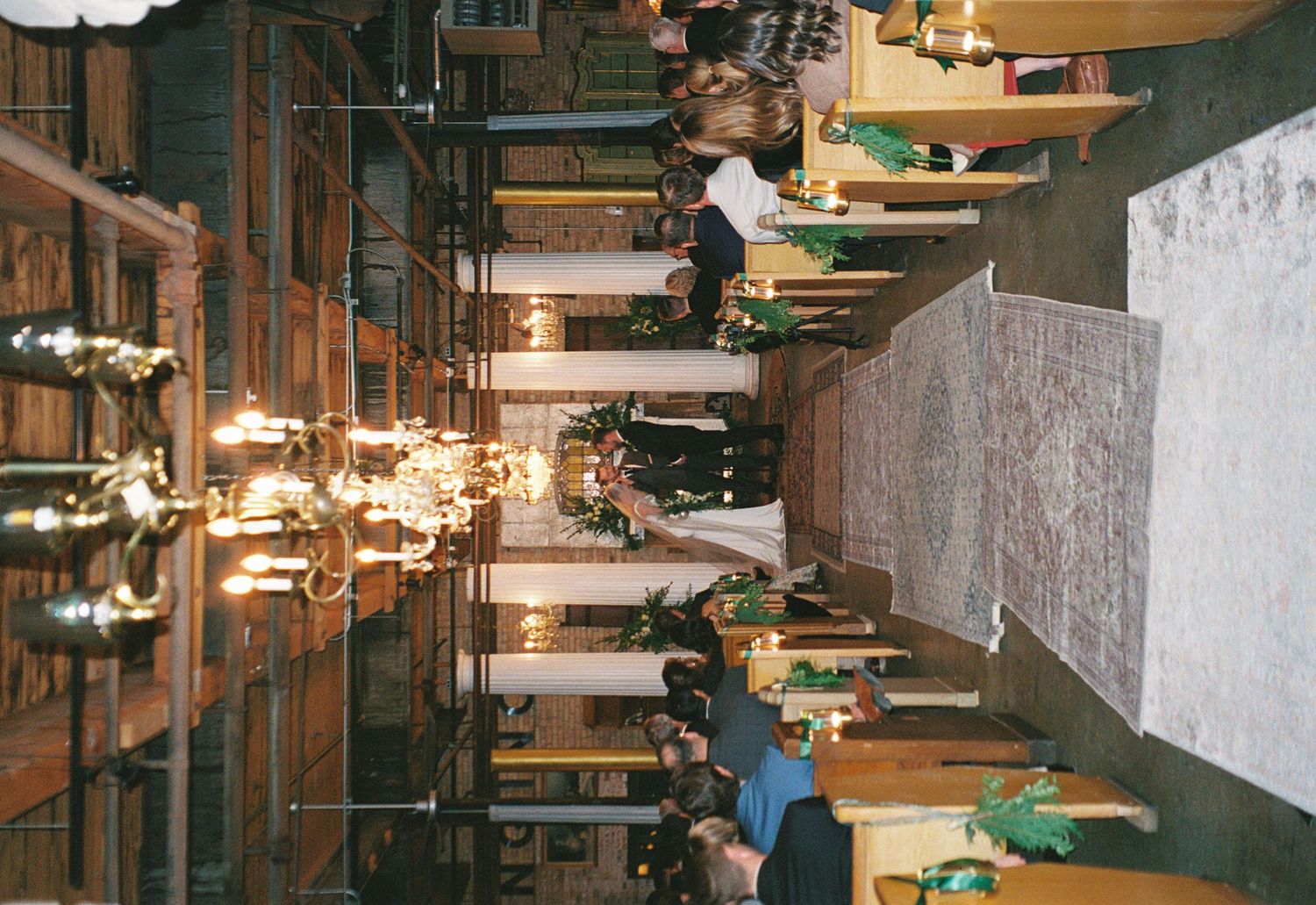 Modern restaurant interior with wooden tables, pendant lighting, and exposed ceiling pipes creates an industrial ambiance.