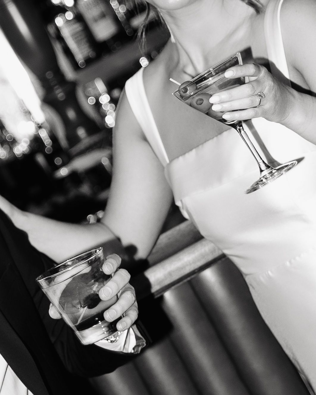 Black and white close-up photo of hands holding wine glasses during a celebration or party.