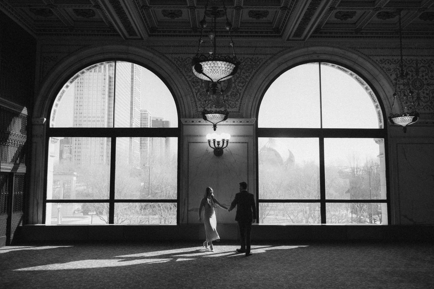 Architectural black and white photograph showing a series of arched windows and doorways in a historic building interior.