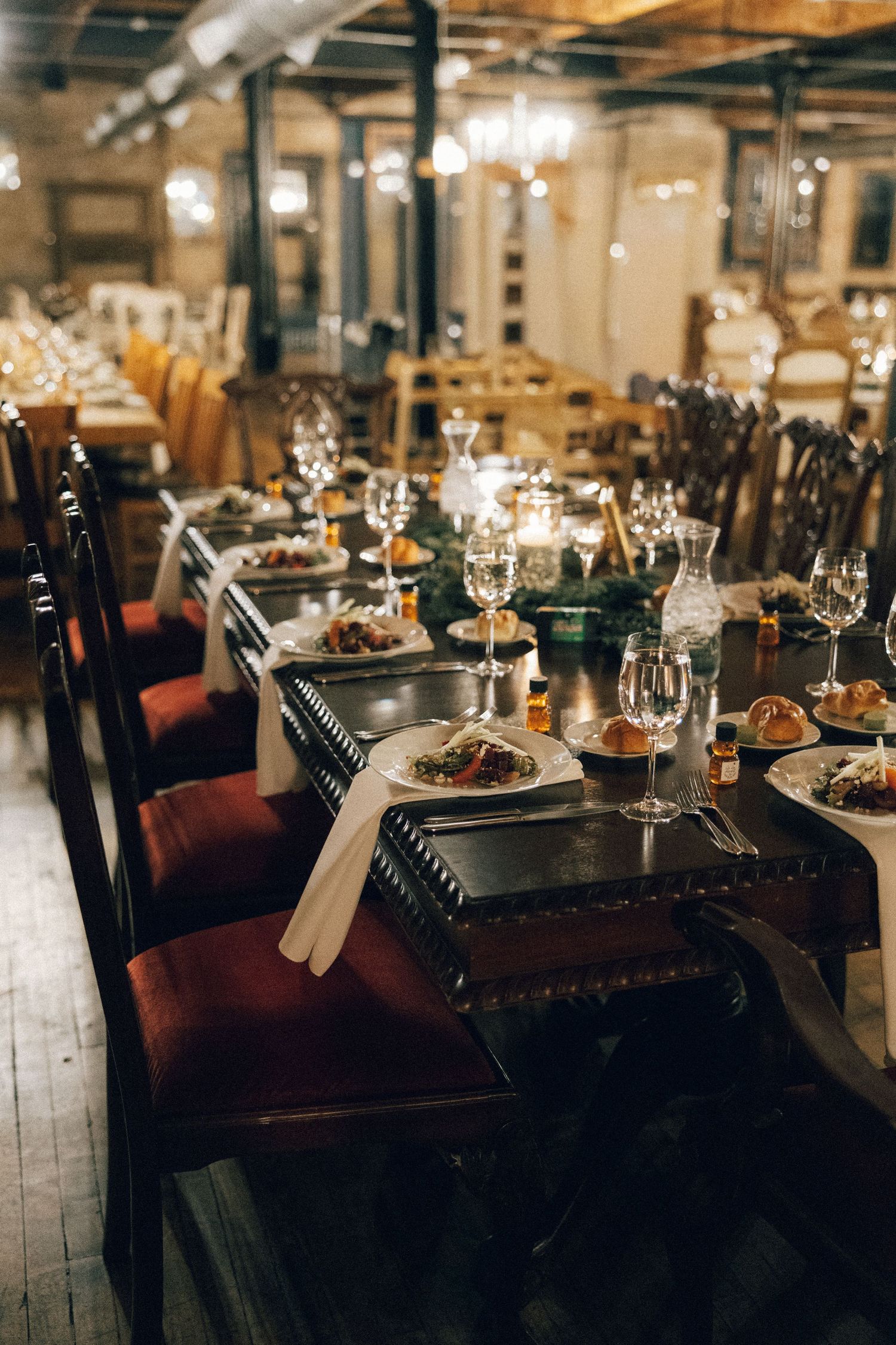 Elegant restaurant dining room with dark wood tables and warm lighting creating an intimate atmosphere.