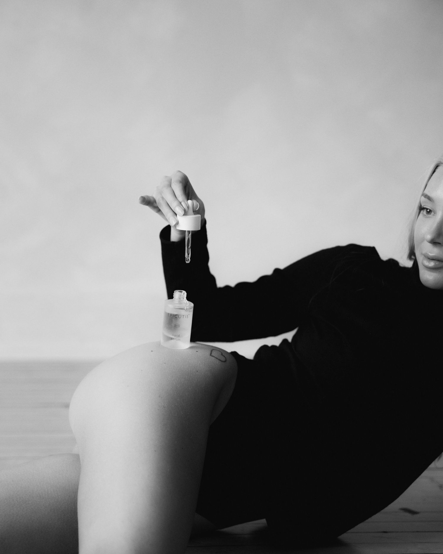 Minimalist black and white sequence showing abstract body forms against a light background.