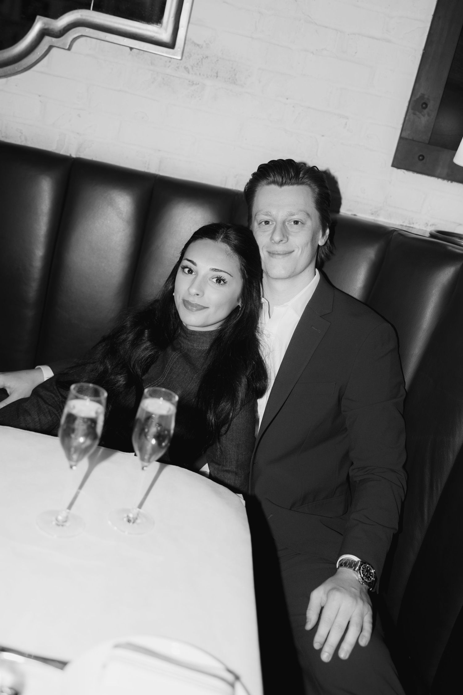 Black and white photo sequence of people sitting at a dining table with drinks in a dimly lit setting.