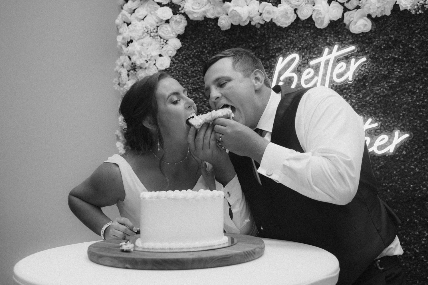 Wedding cake feeding sequence with white balloon decorations in monochrome style.