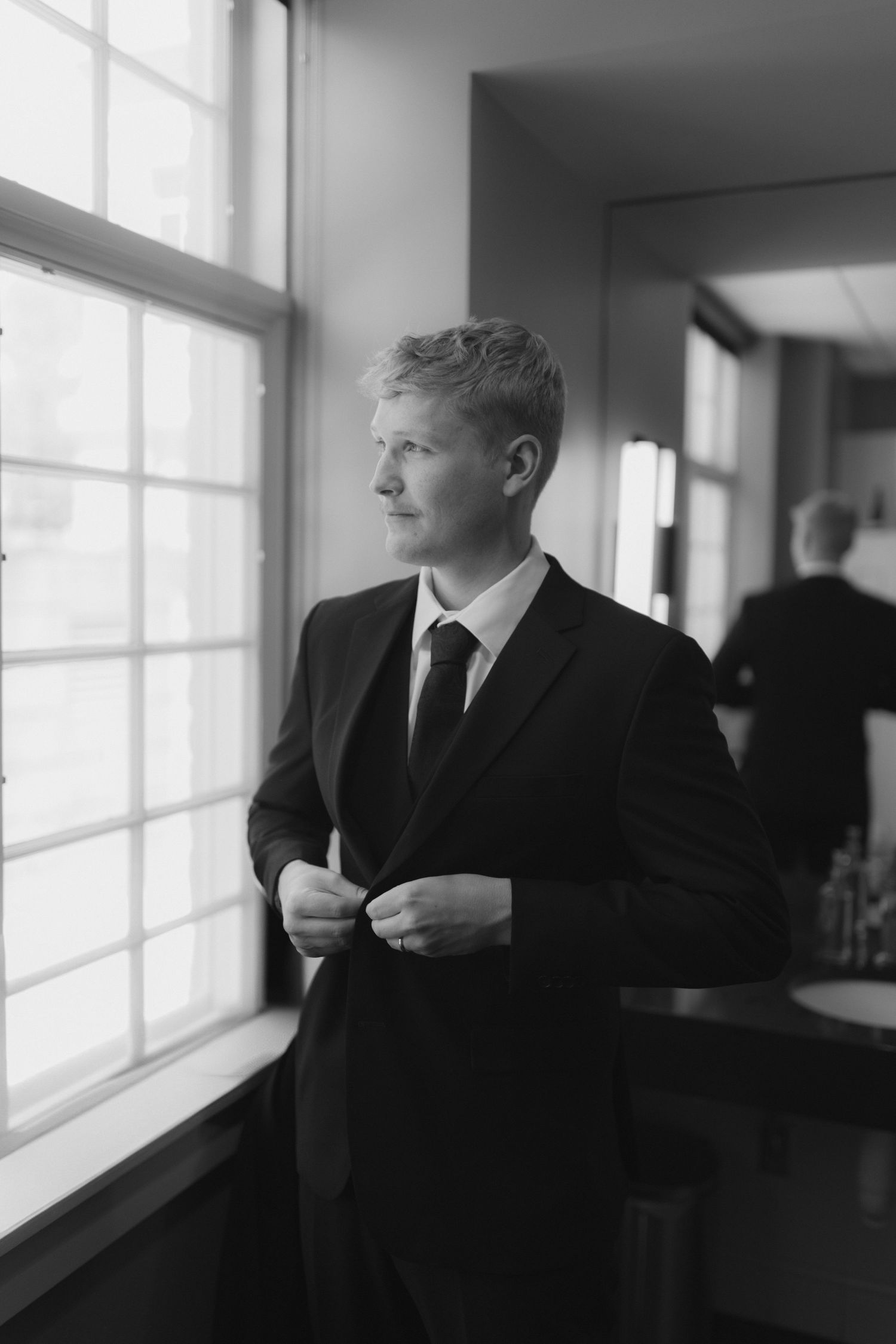 Black and white portraits taken near bright windows in formal attire.