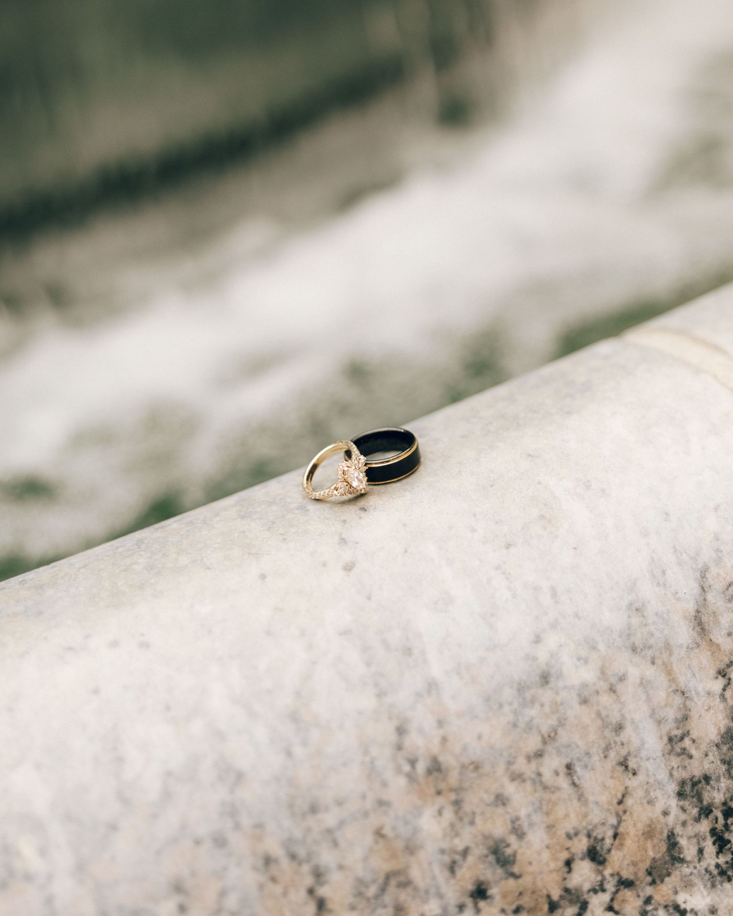 Wedding rings displayed on textured white stone surface.