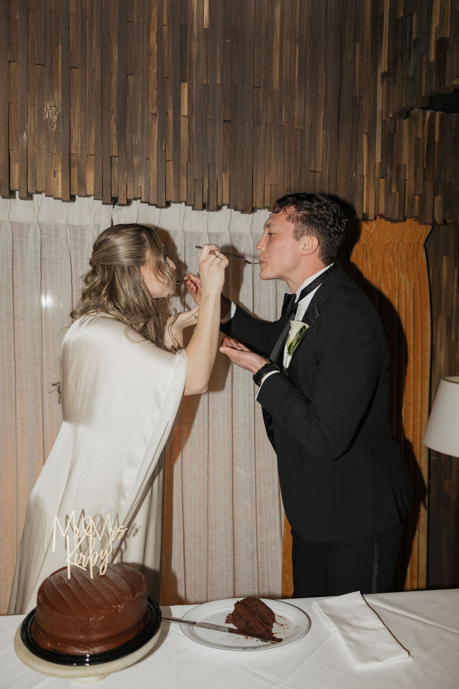 Sequence of photos showing newlyweds taking ceremonial first bites of chocolate wedding cake at reception.