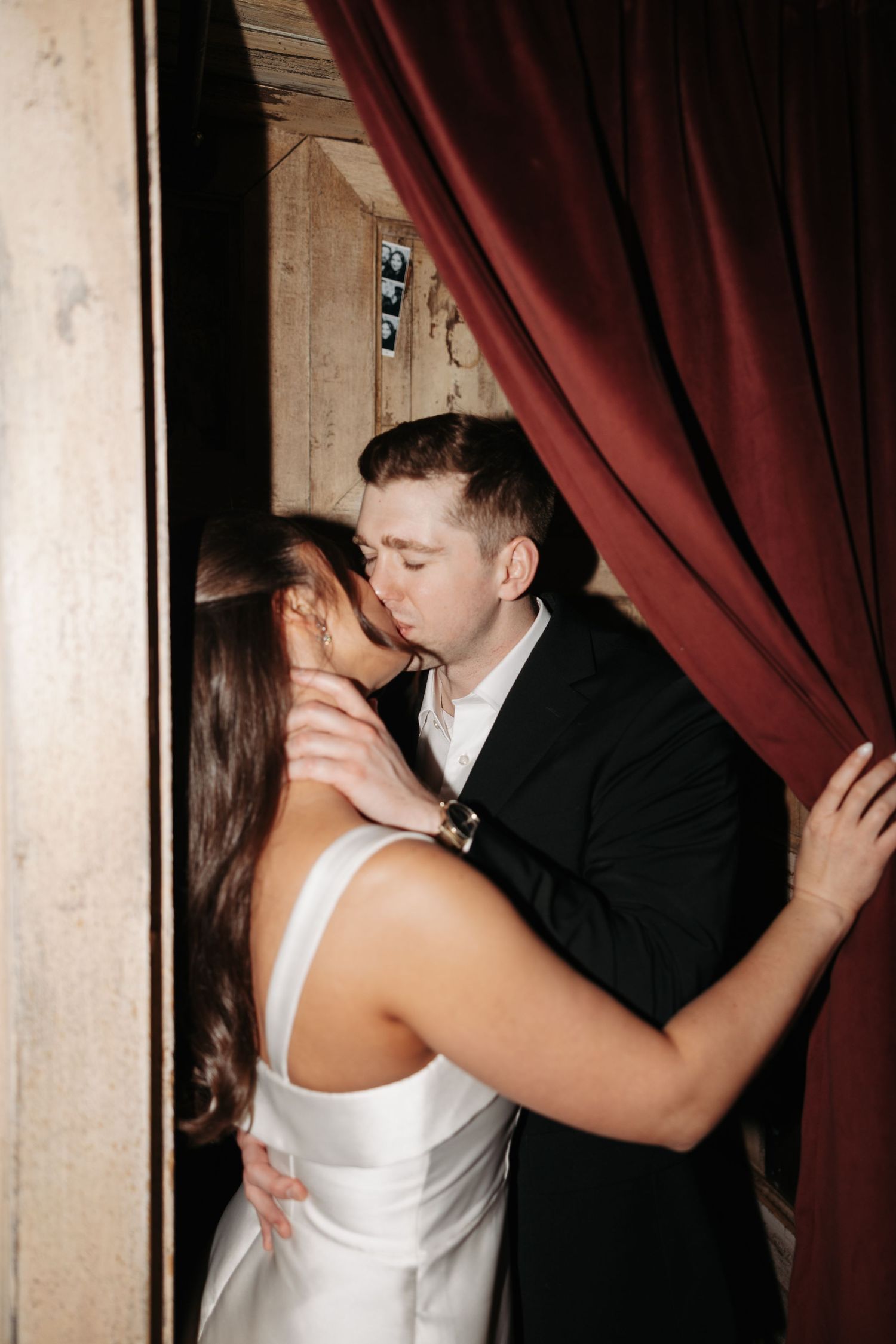 A romantic couple shares an intimate moment against a red curtain backdrop in a sequence of wedding photos.