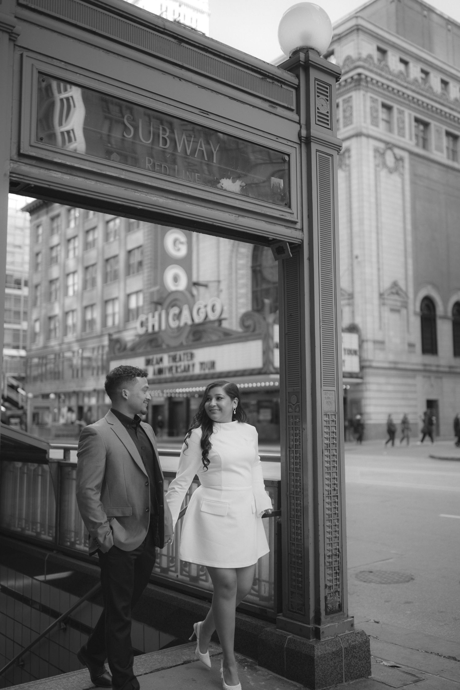 Vintage black and white photograph showing people entering and exiting a Chicago subway station entrance in the 1950s.