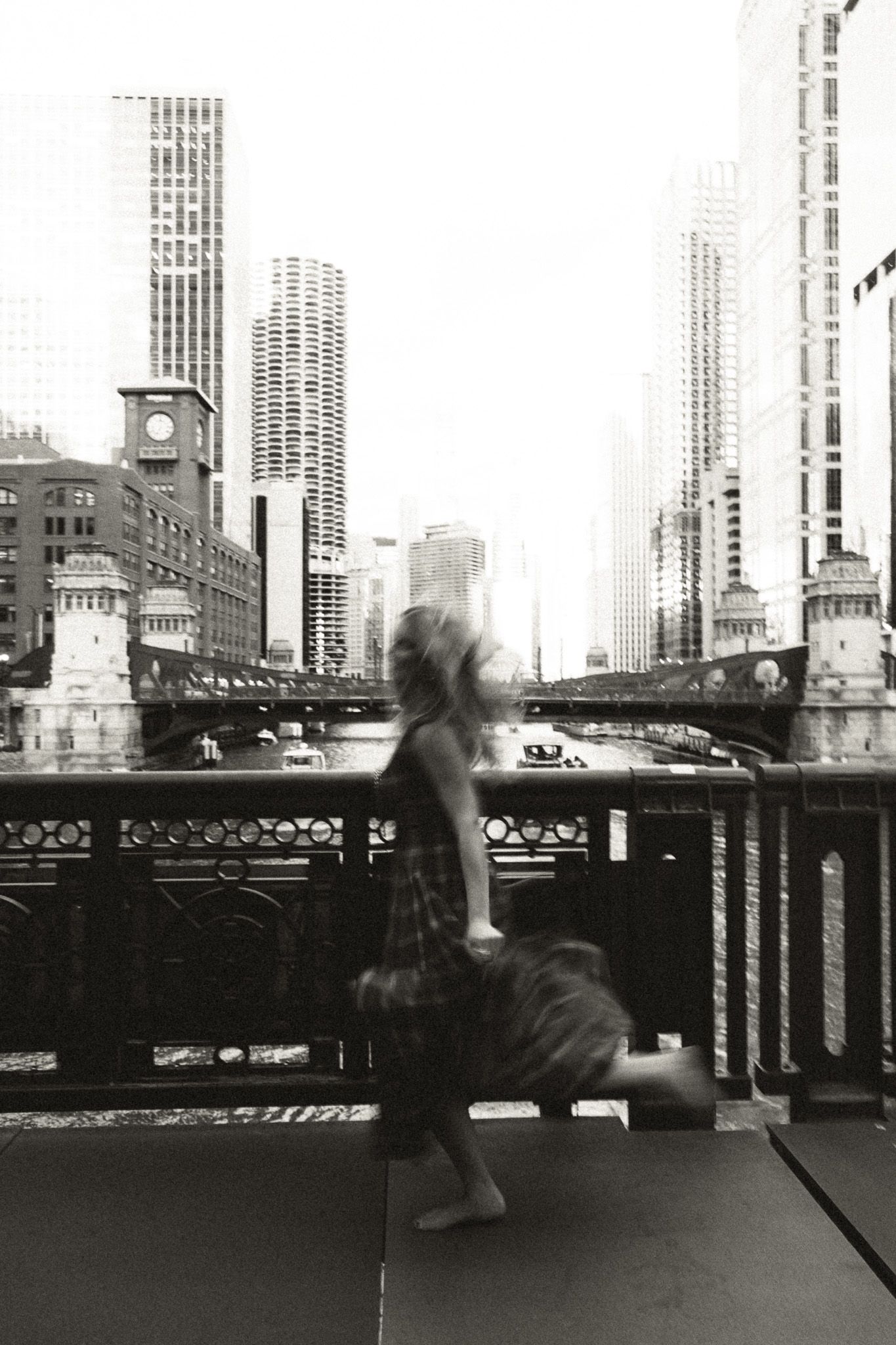 A black and white sequence showing movement across an urban rooftop with skyscrapers in the background.