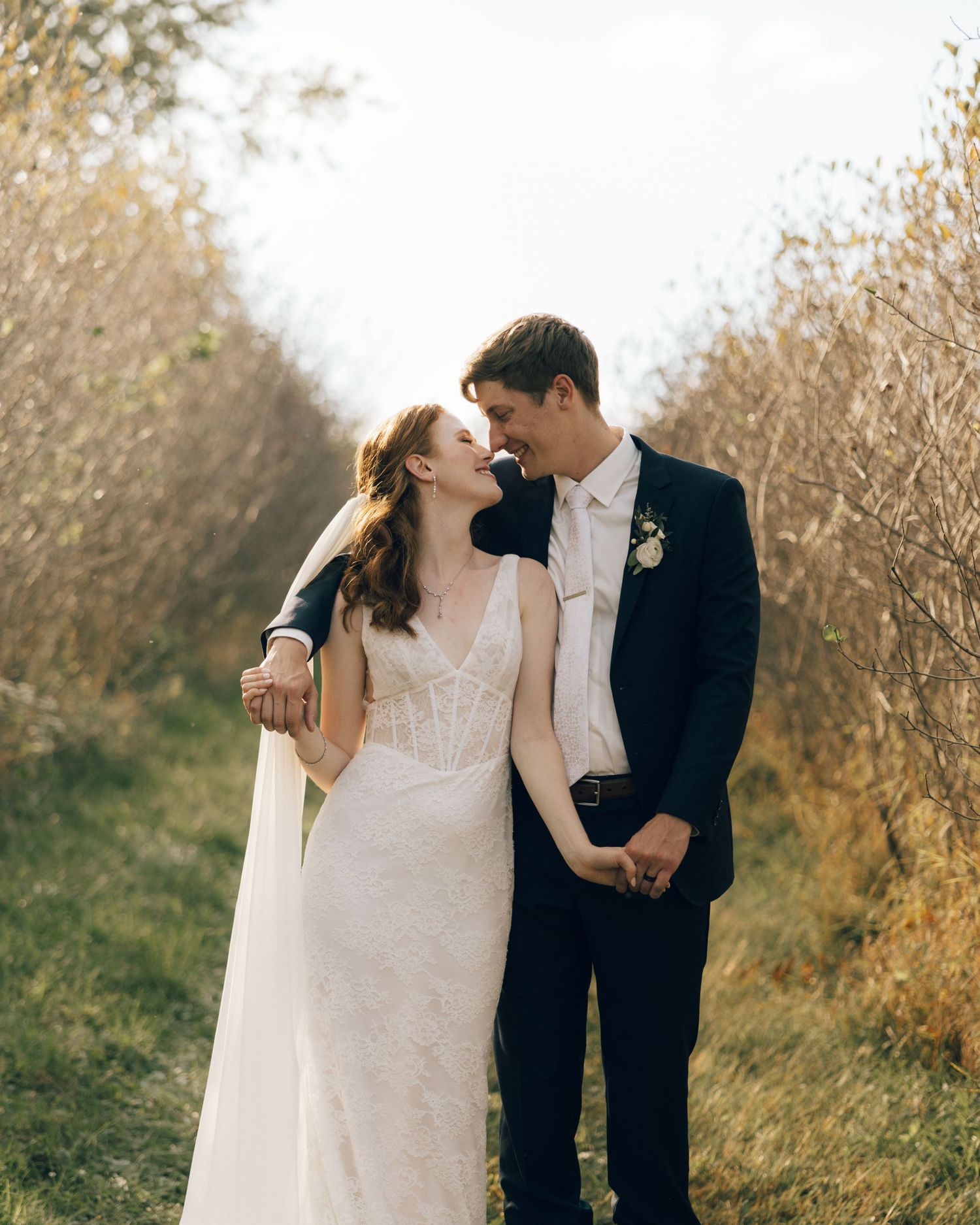 A romantic wedding photoshoot in a golden field during sunset.