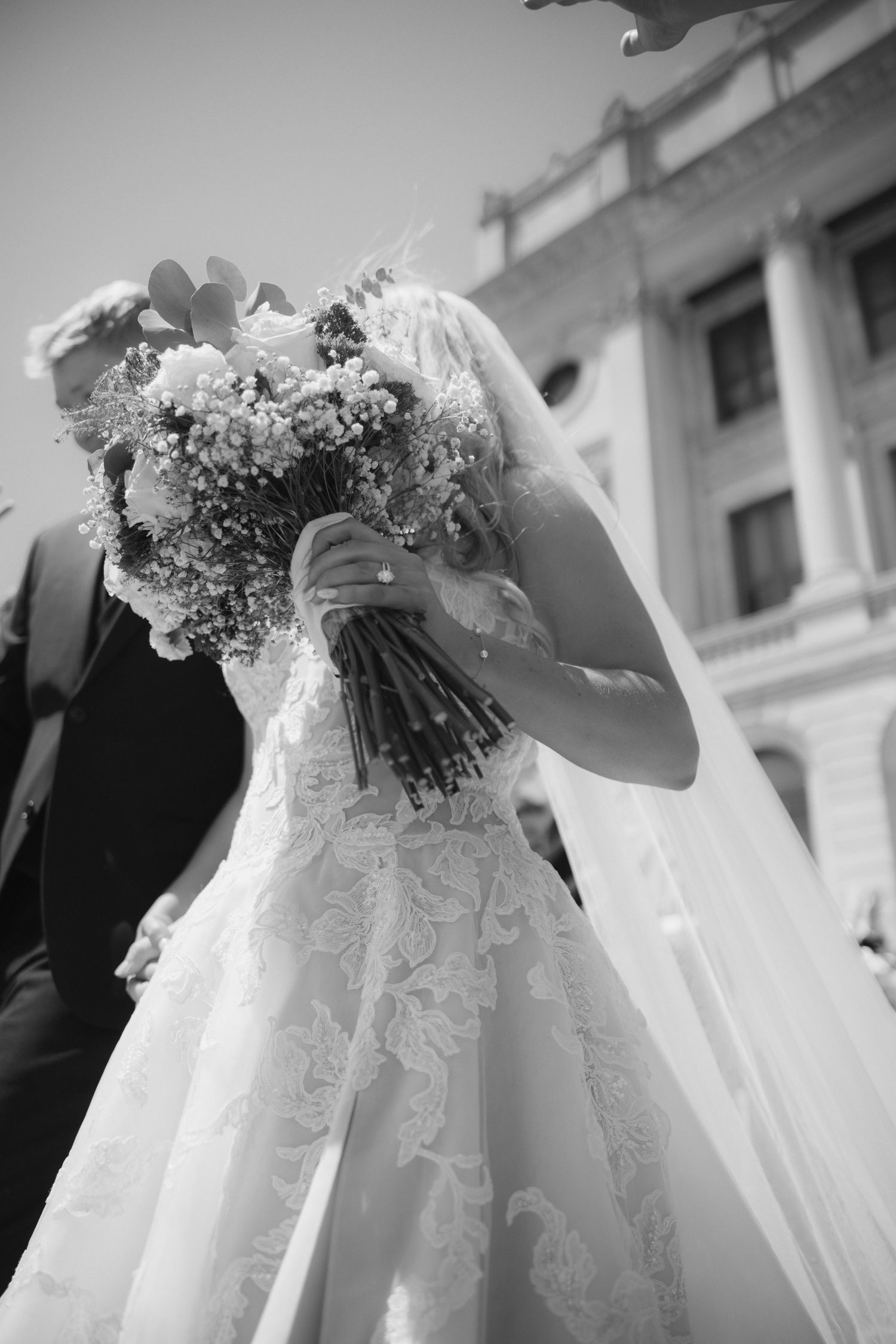 Wedding veil and lace dress details captured in dramatic black and white photography.