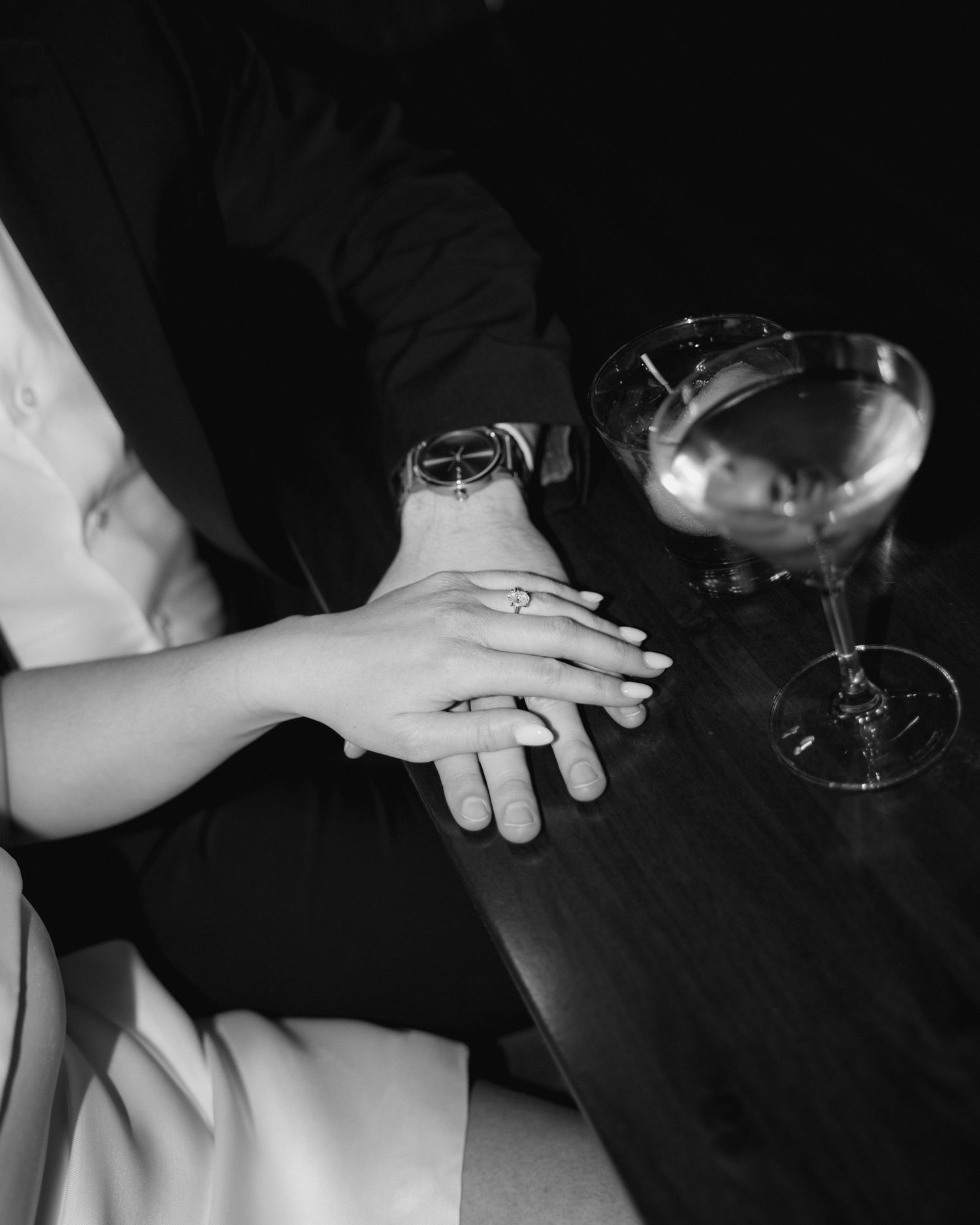 A series of black and white photos showing hands holding wine glasses in various poses against dark backgrounds.