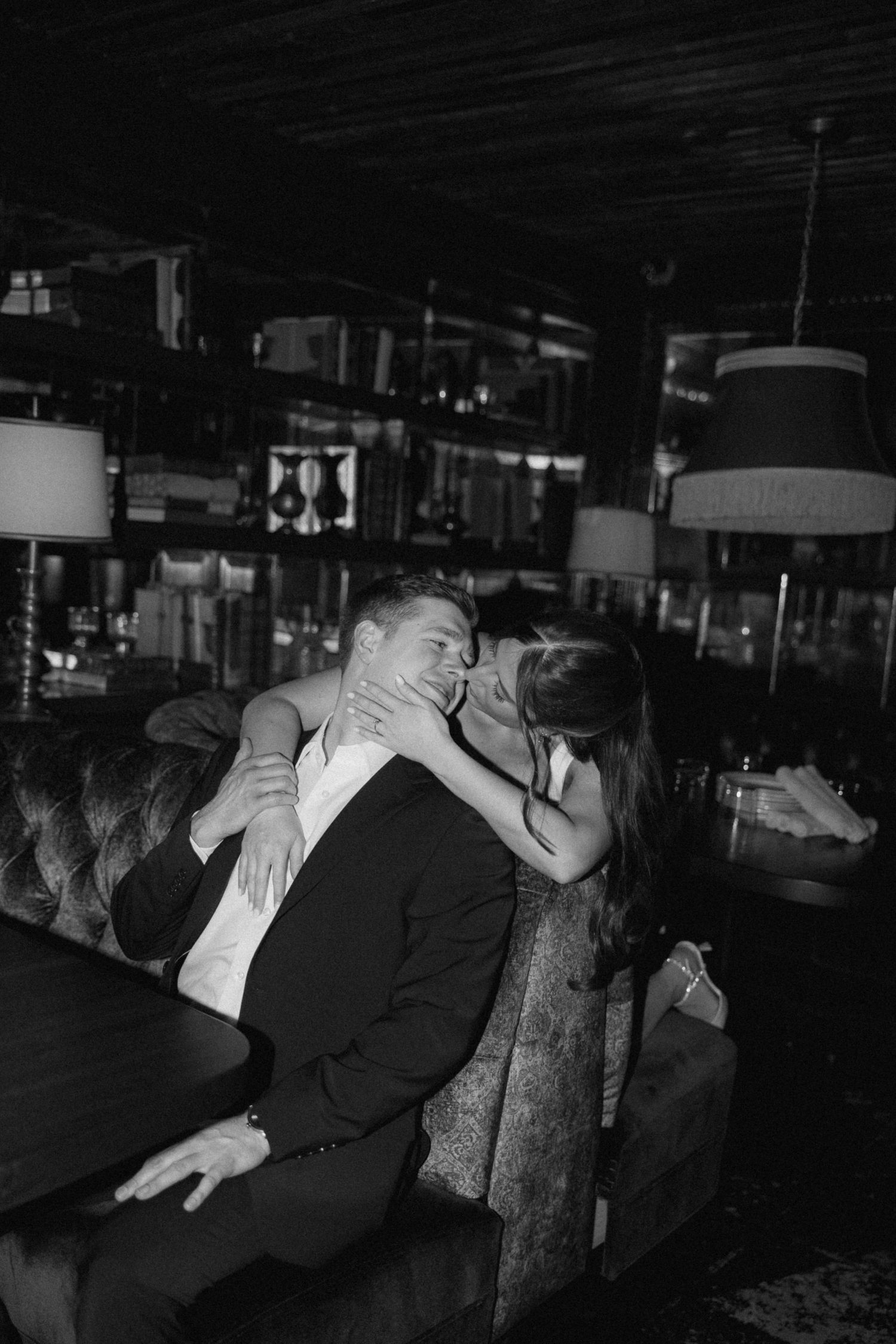 A couple embraces in a dramatic dance pose against a dark, moody backdrop.