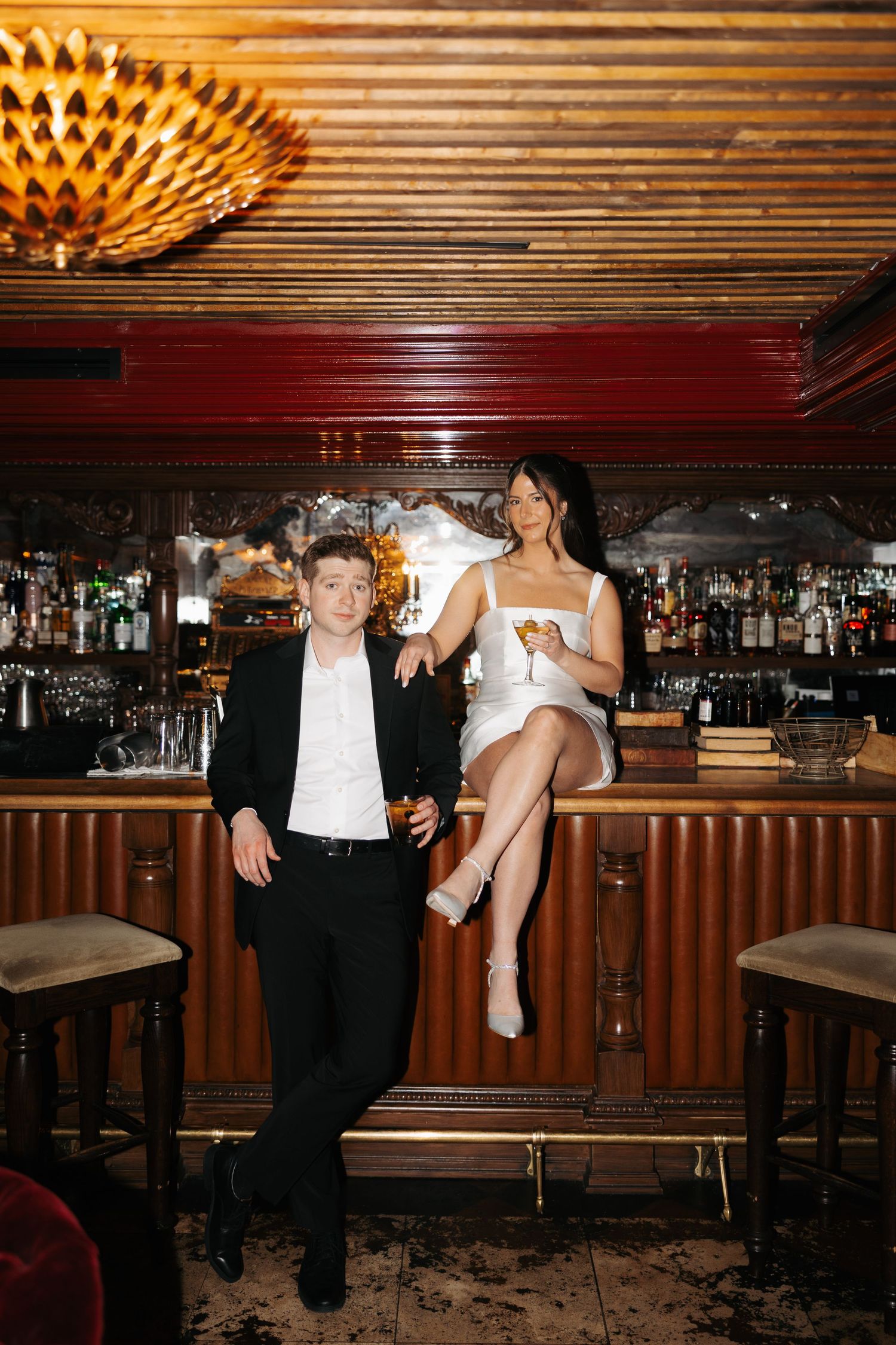 A sequence of playful dance moves captured at a bar with wooden paneling and decorative lighting.