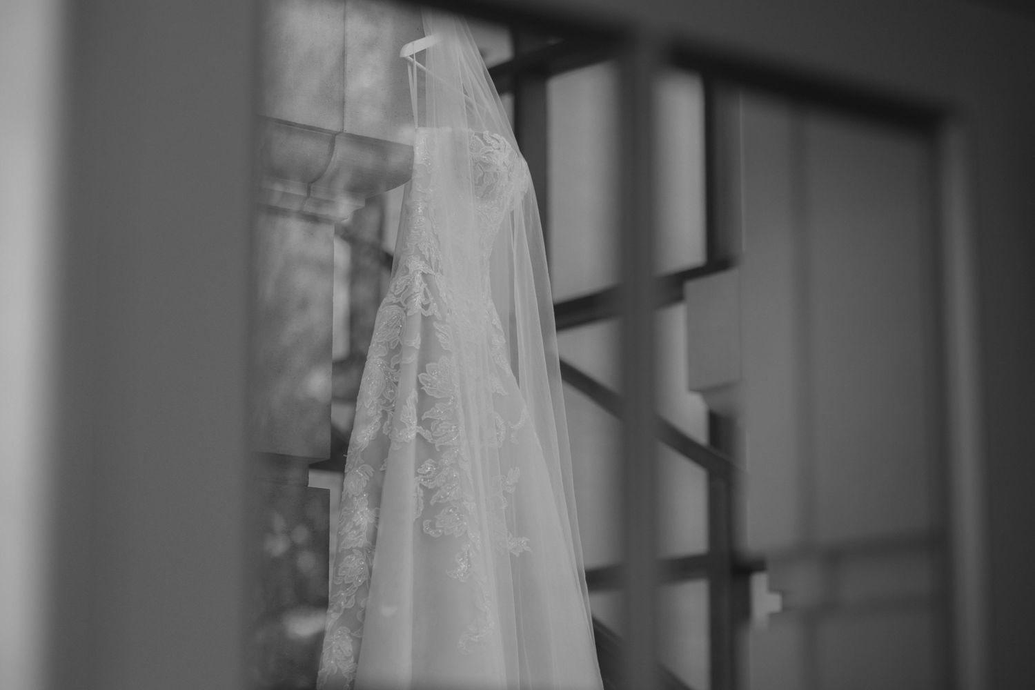 White wedding dresses hang in a row against a dark background creating an elegant display.