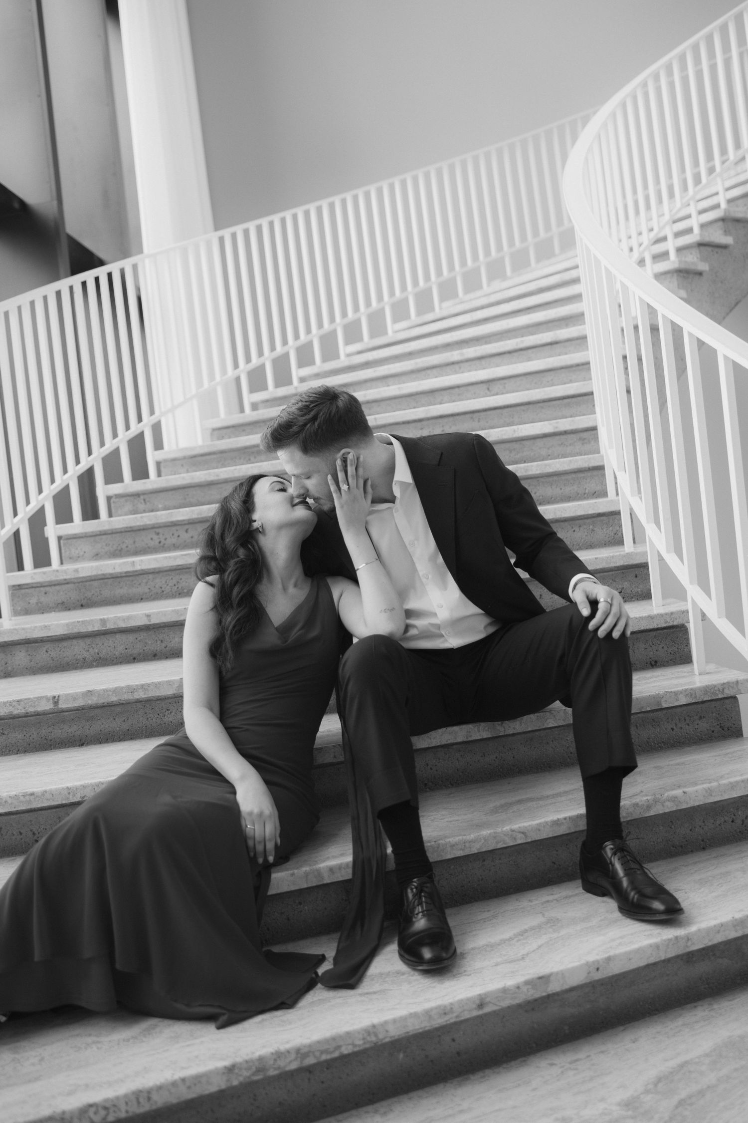 A series of black and white photos showing a couple in formal attire posing dramatically on white stairs.