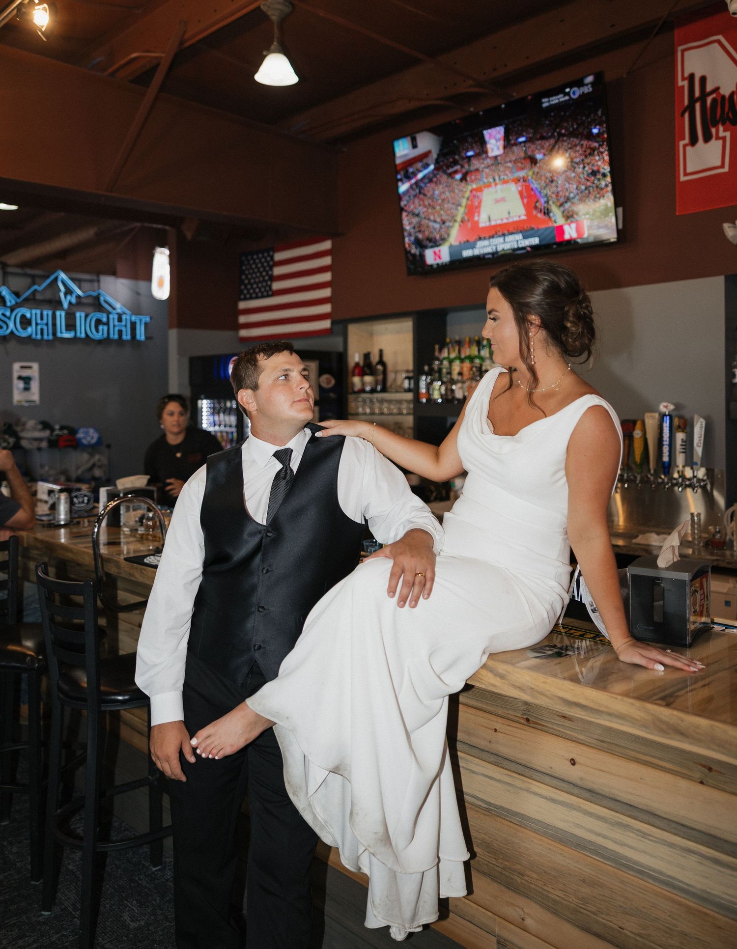 Wedding celebration at a casual bar venue with wooden countertops and American flag decor.