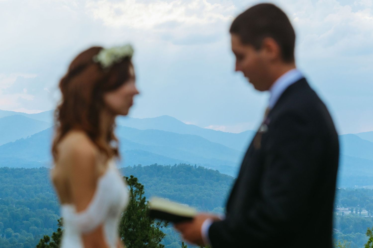 Bride and groom exchange vows with stunning Blue Ridge Mountain panorama in background.