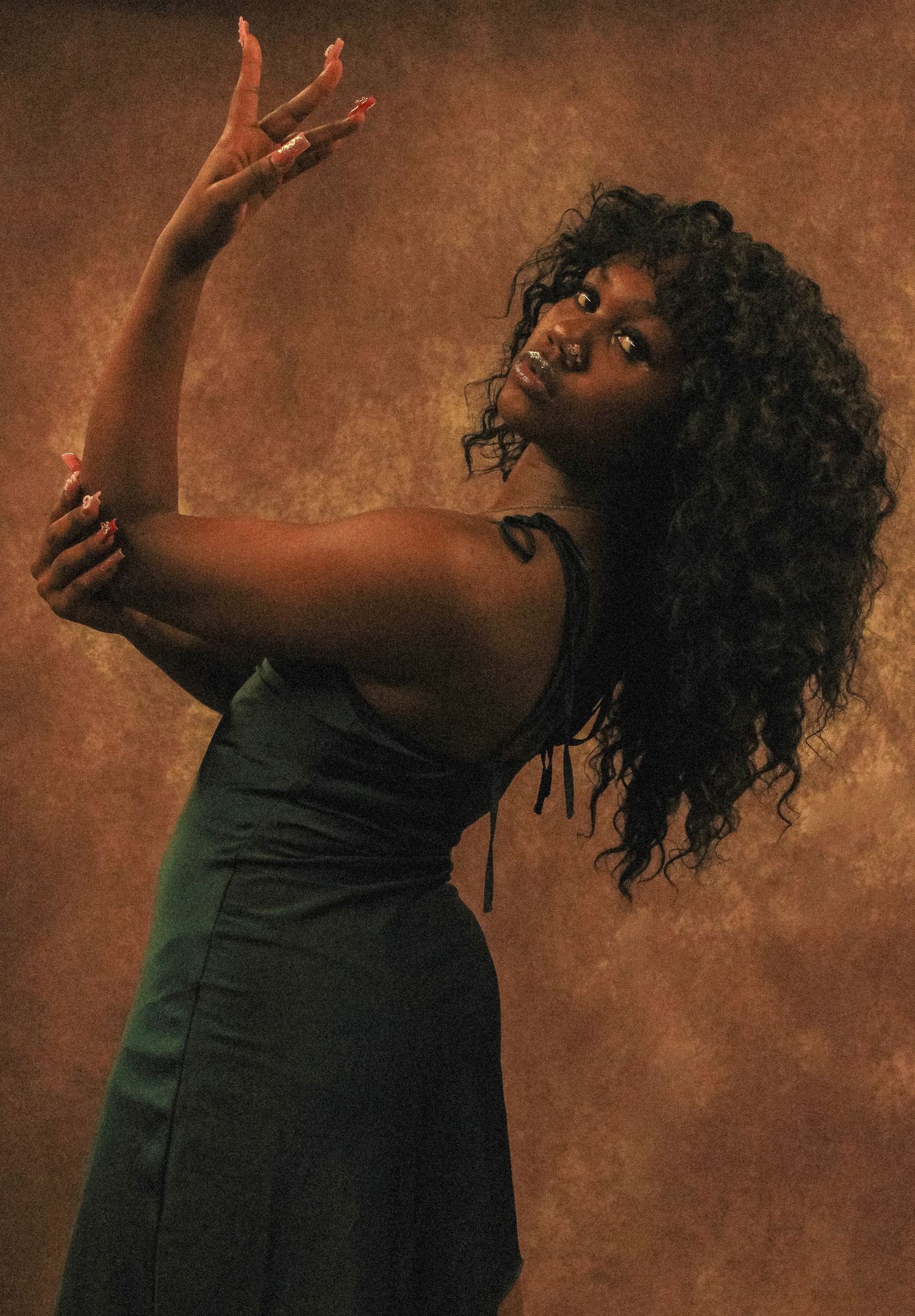 Artistic dance-like poses in dark clothing against textured brown backdrop.