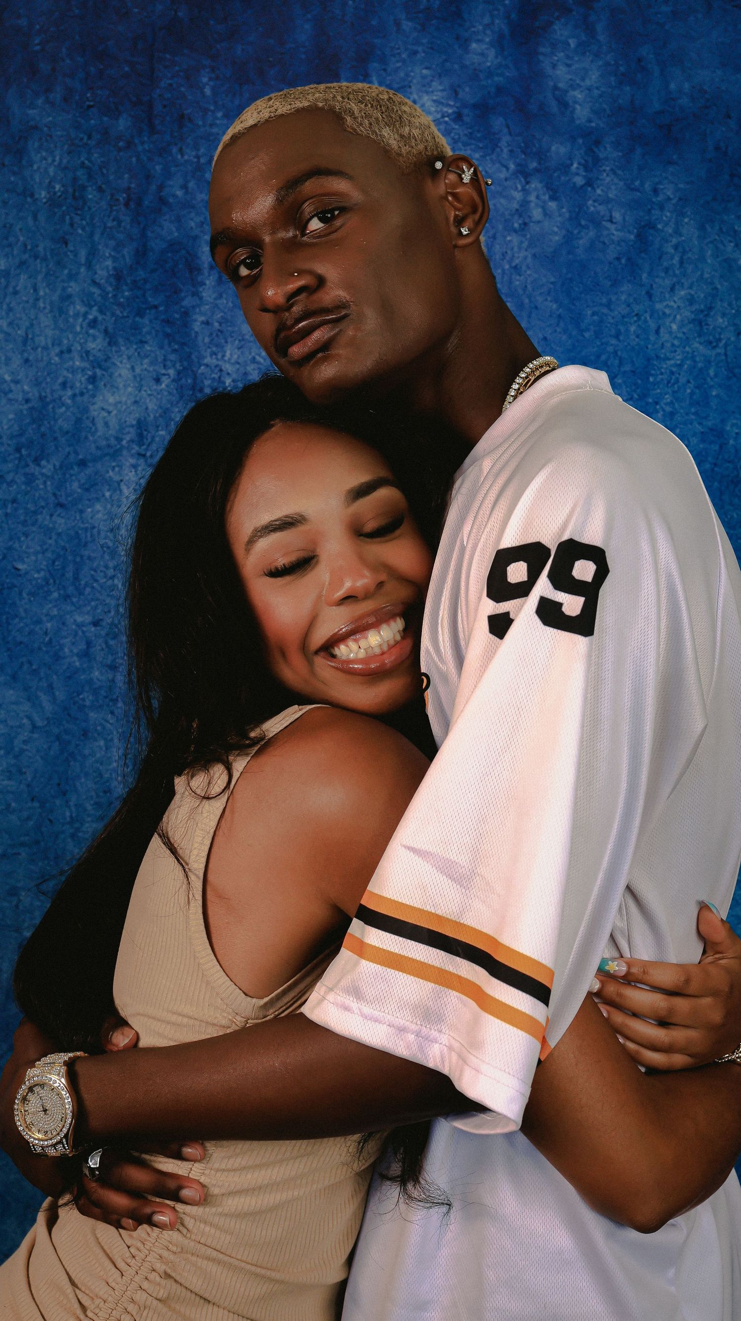 A tender moment between two people embracing in studio lighting.