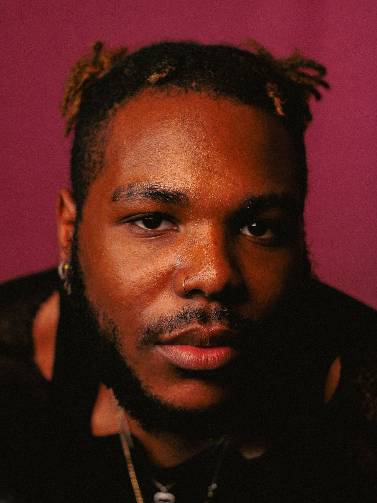 Artistic portrait series showing different angles and expressions against crimson background.
