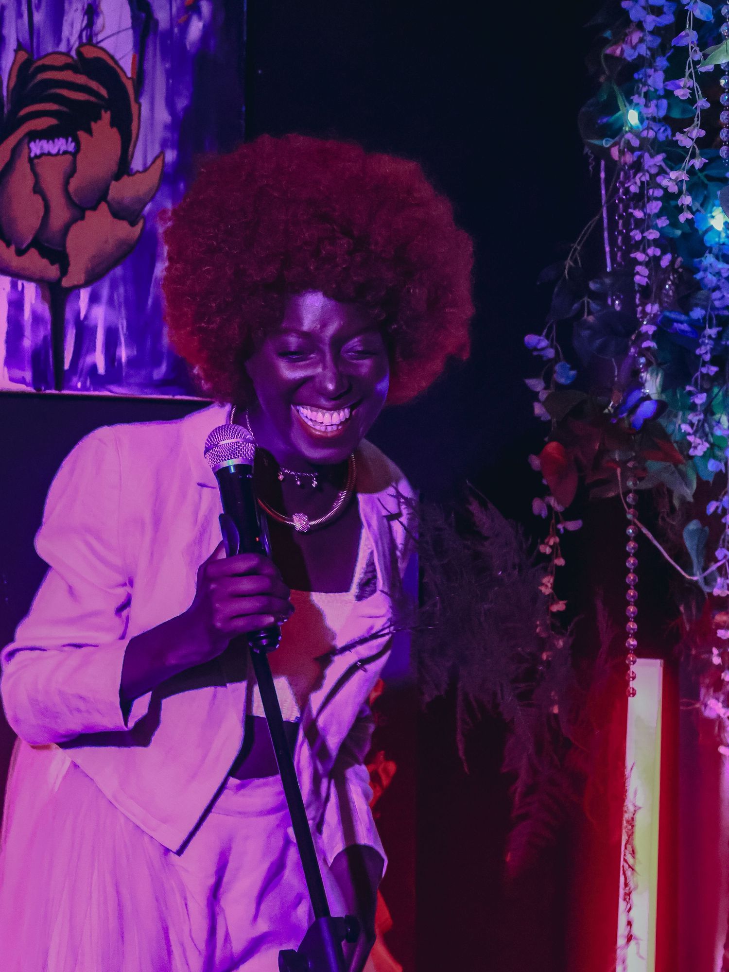 An energetic stage performance with dramatic purple lighting and joyful expressions.