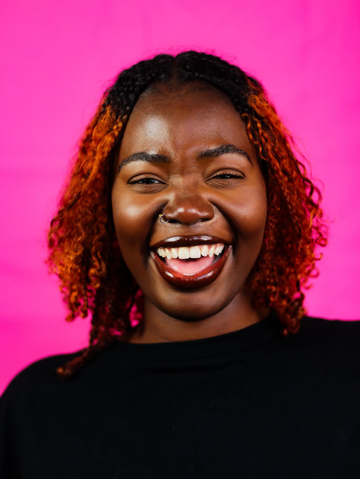 Candid laughter sequence captured against bright pink studio backdrop.