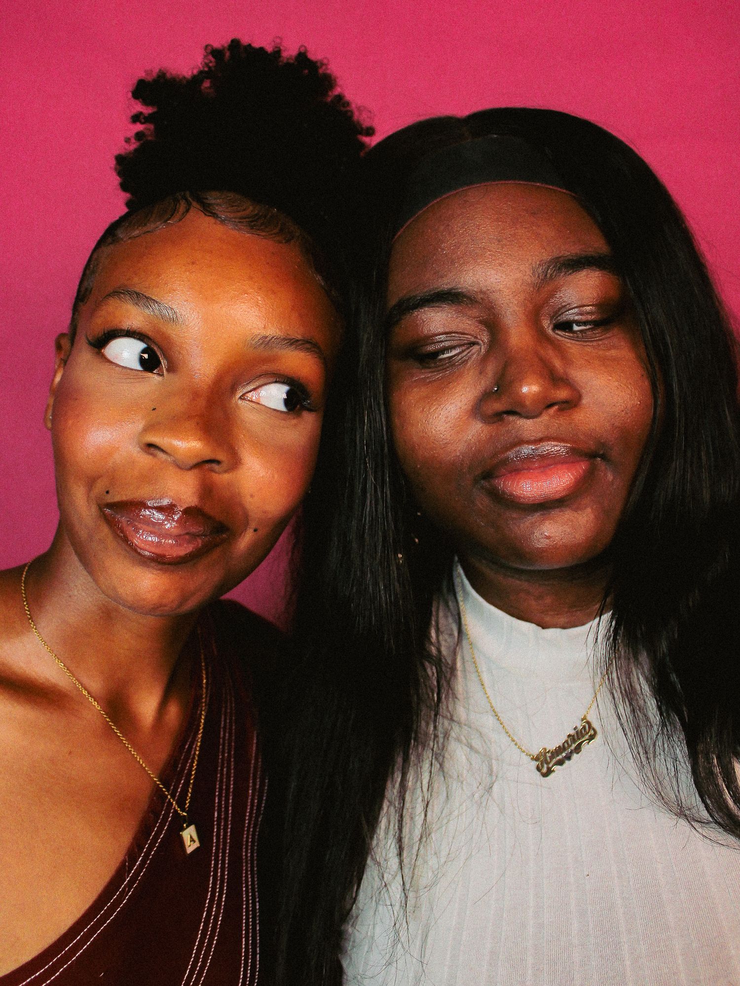 Two friends pose expressively for a series of candid shots against pink wall.