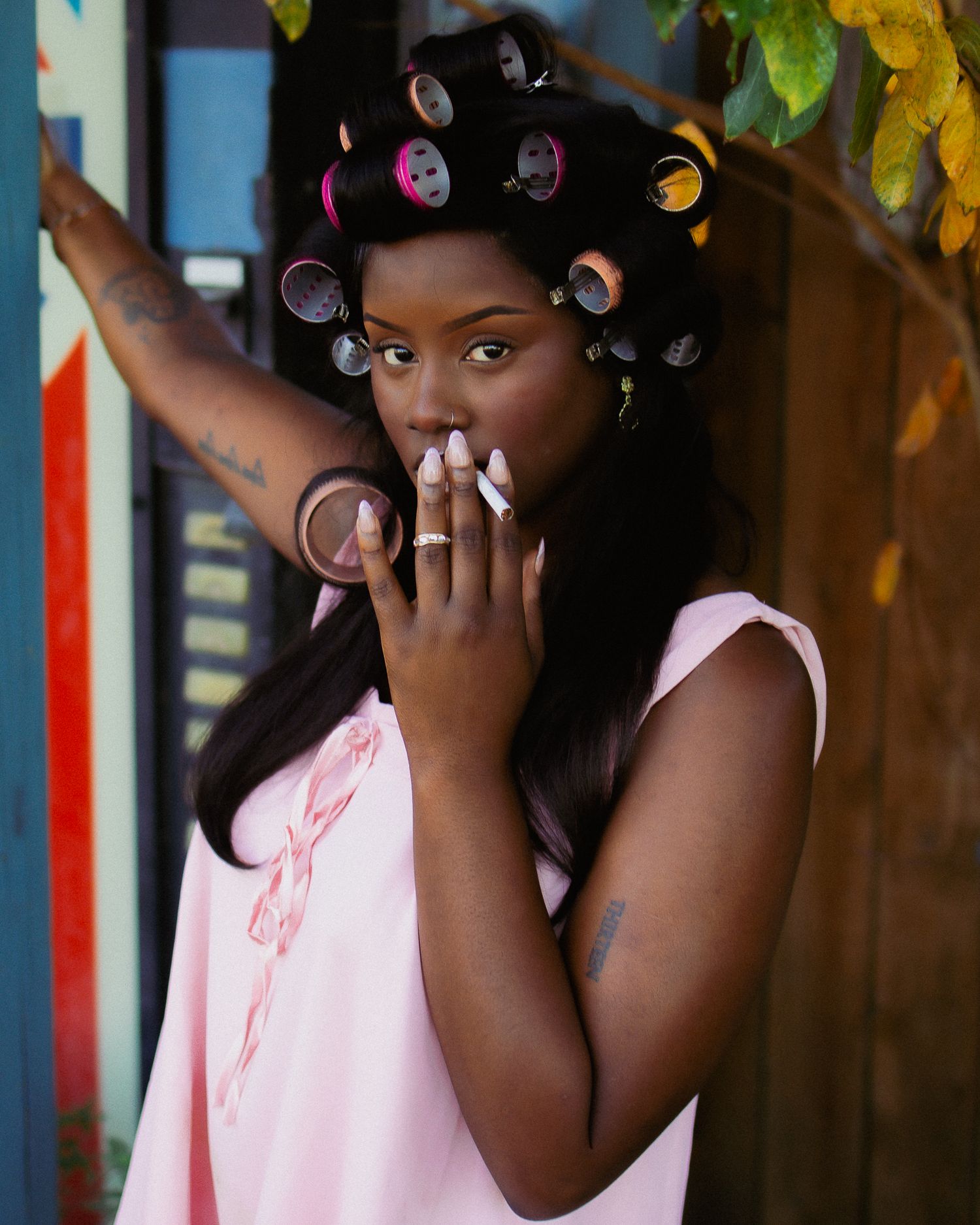 Expressive portrait with vintage Pepsi signage and natural greenery.