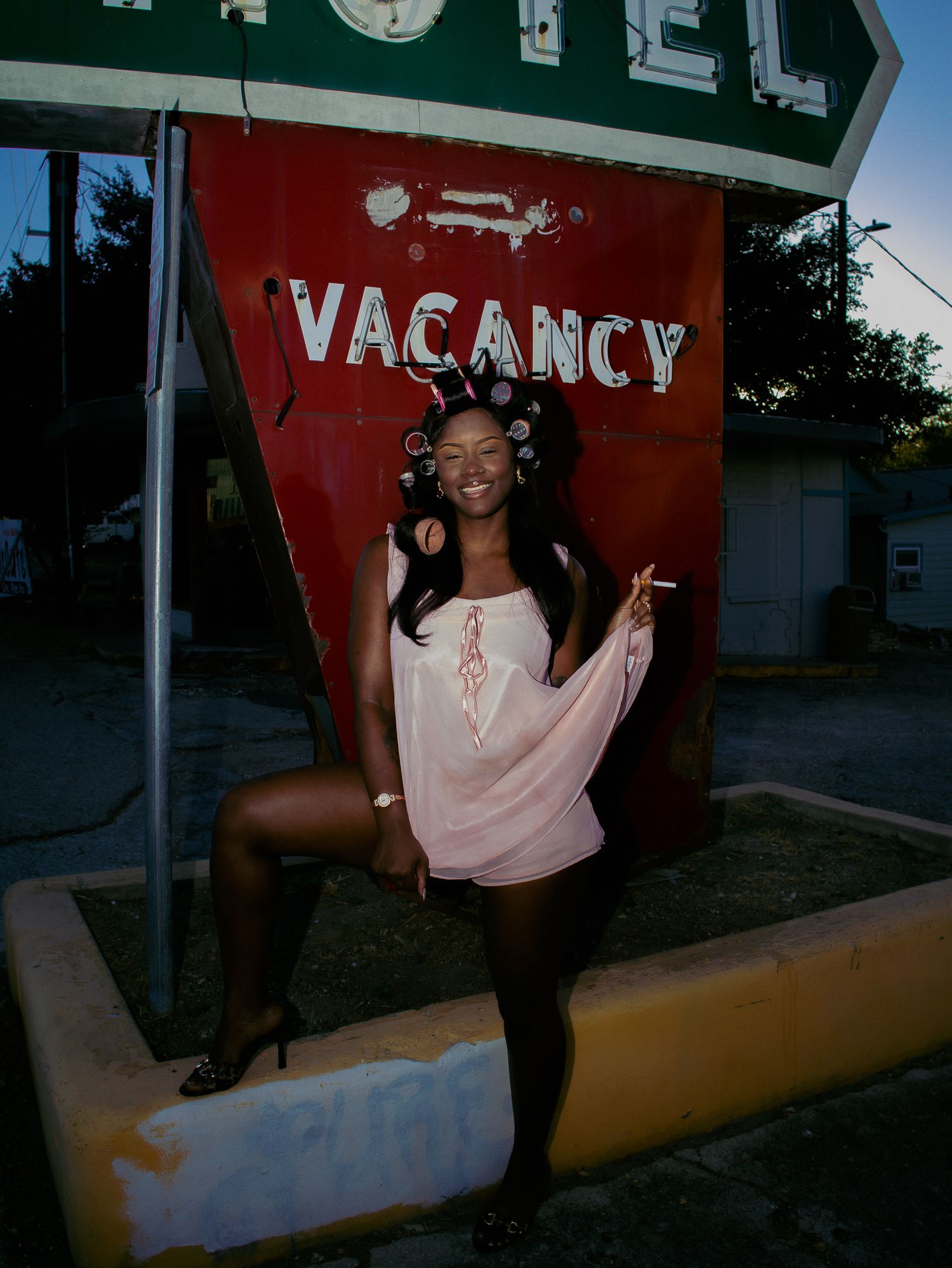 Stylized portrait session showcasing dynamic poses against a motel backdrop.