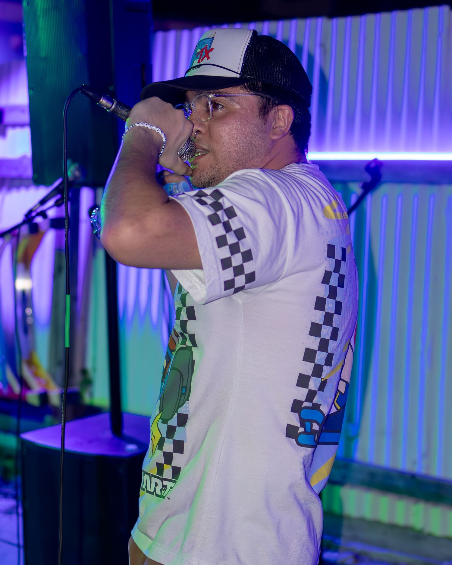 Live performance shot with gaming-themed clothing under colorful venue lighting.