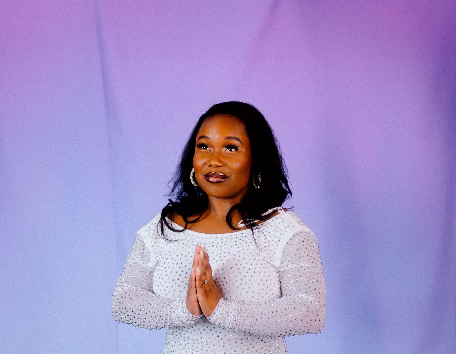 Fashion portrait in white sequined dress against purple gradient backdrop.