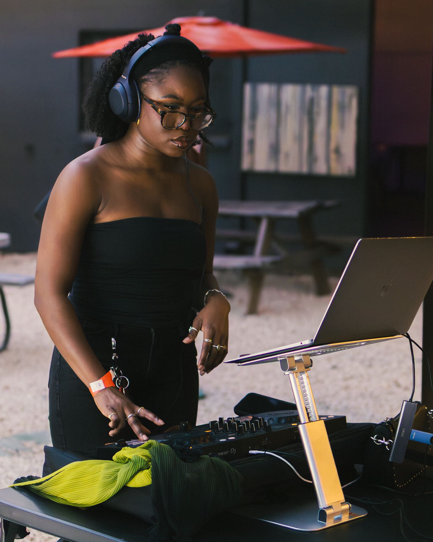 DJ performing at a nighttime event using professional equipment and laptop while wearing headphones.