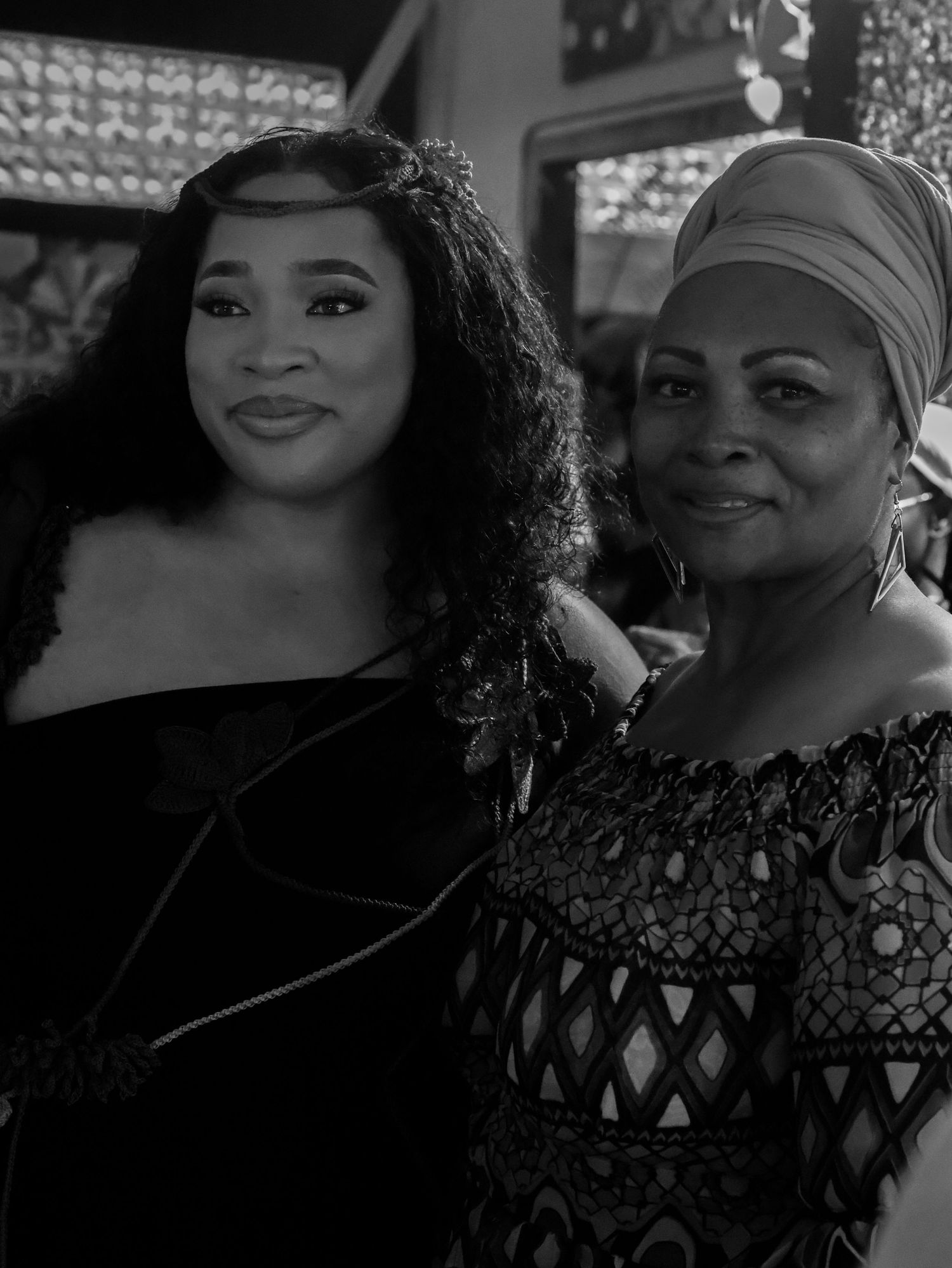 Black and white photograph of people wearing patterned clothing and accessories.