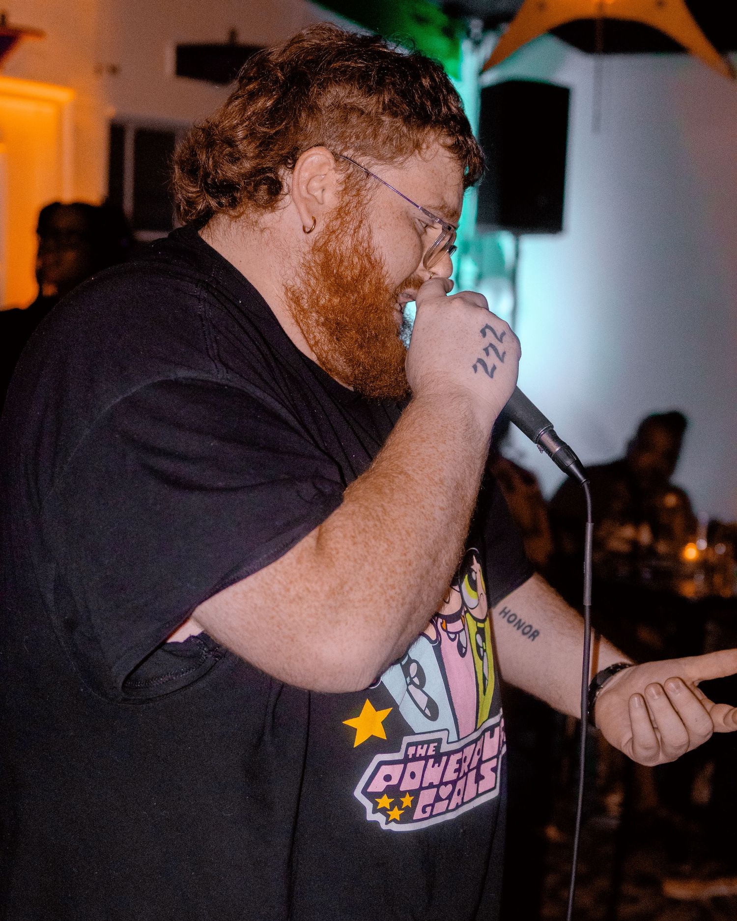 Performance shot showing cartoon character t-shirt design under dramatic stage lighting.