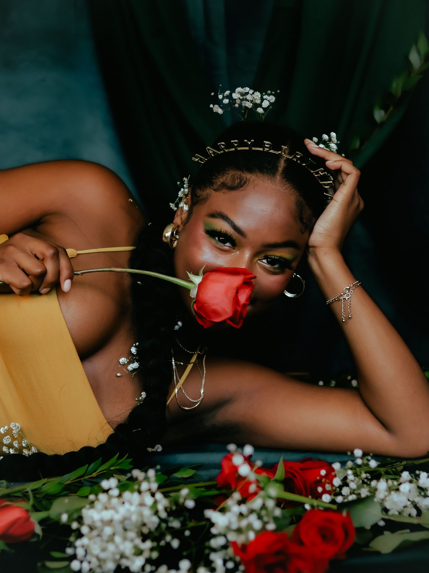 Creative portrait with red roses and delicate white flowers in moody lighting.