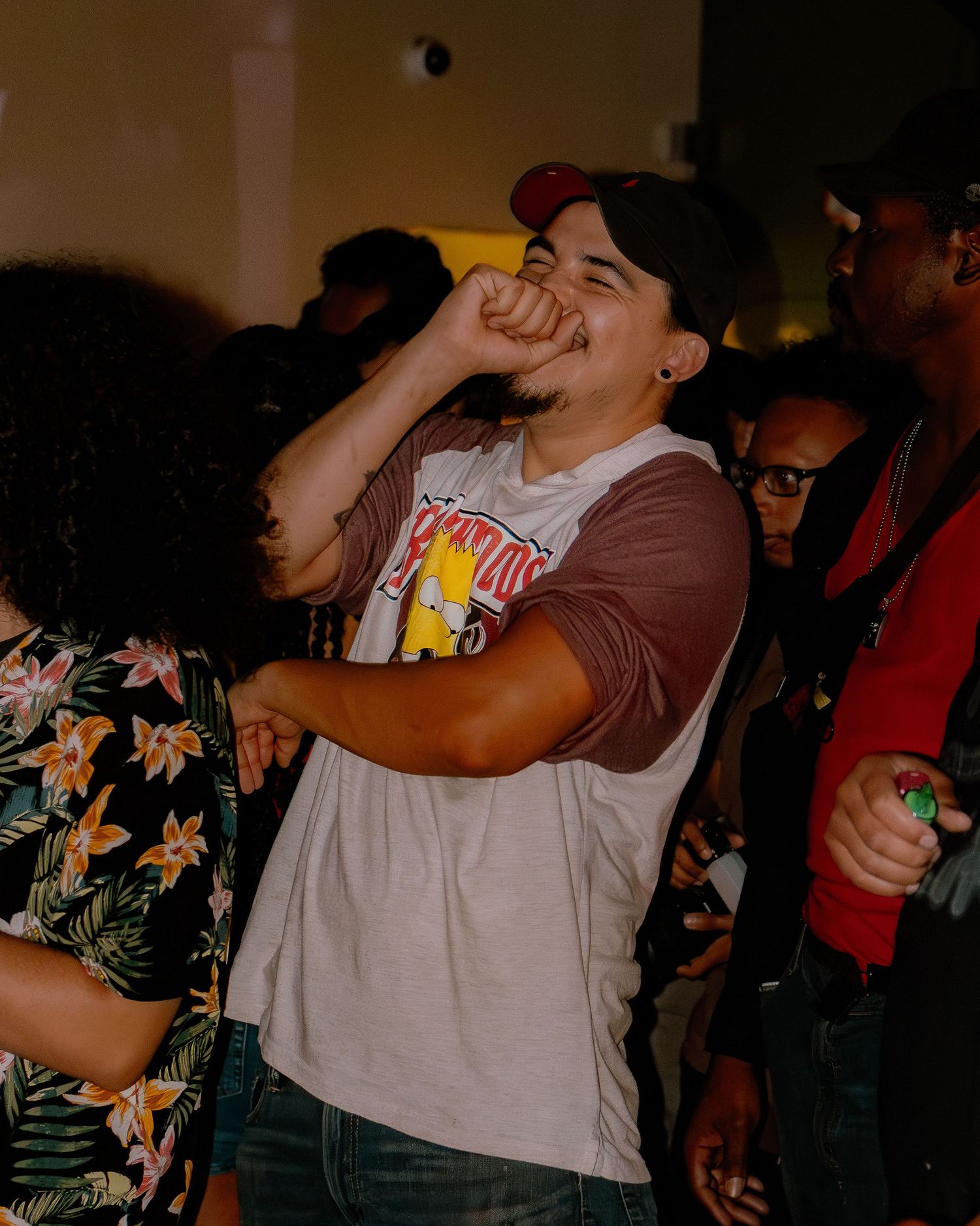 People drinking and dancing at a dimly lit party or club event.