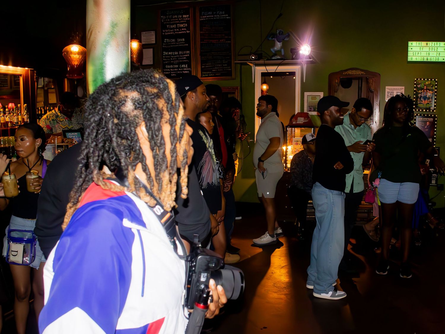A dimly lit indoor venue with a crowd gathered for an event.