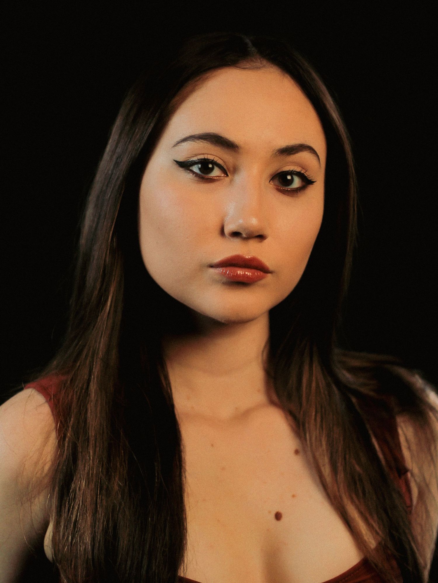 Dramatic black background portraits showing dark hair and red lipstick.