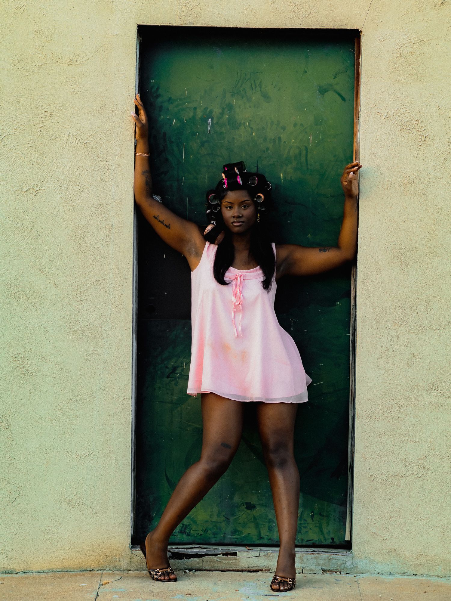 Dance-like movements captured in a series against a green doorway wearing pink.