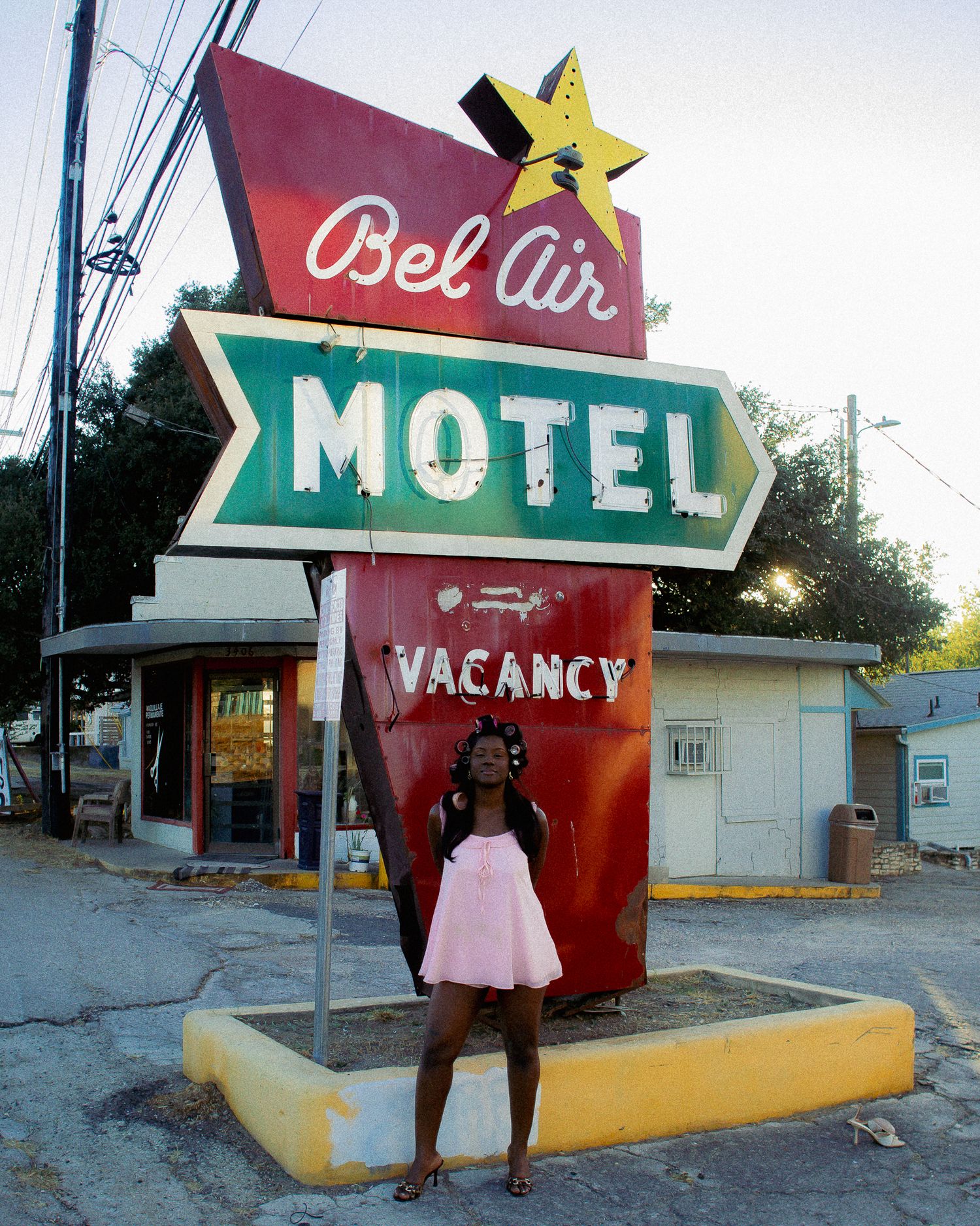 Vintage motel sign with star decoration and vacancy notice at dusk.