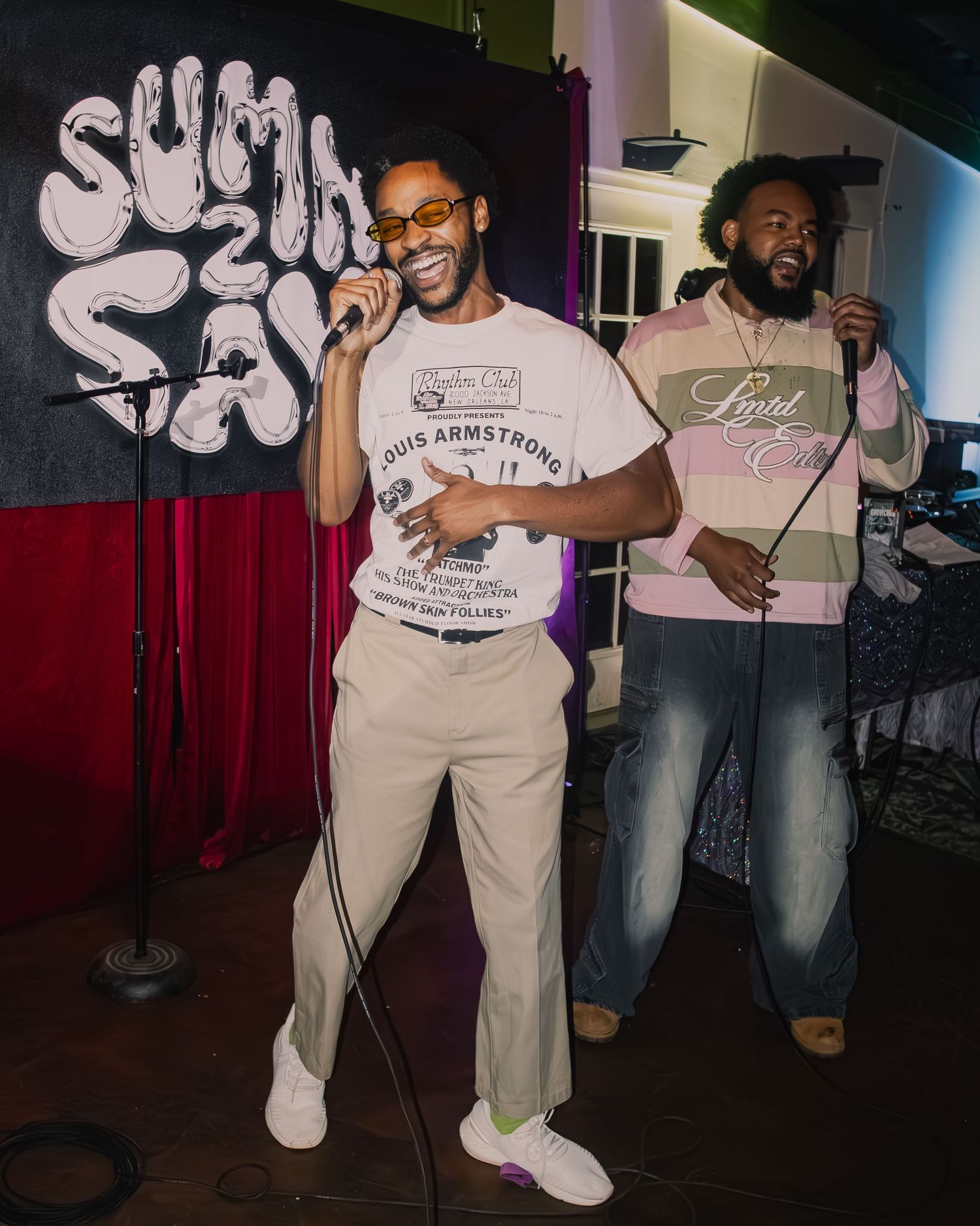 Live performance in intimate venue with dramatic lighting and street art backdrop.
