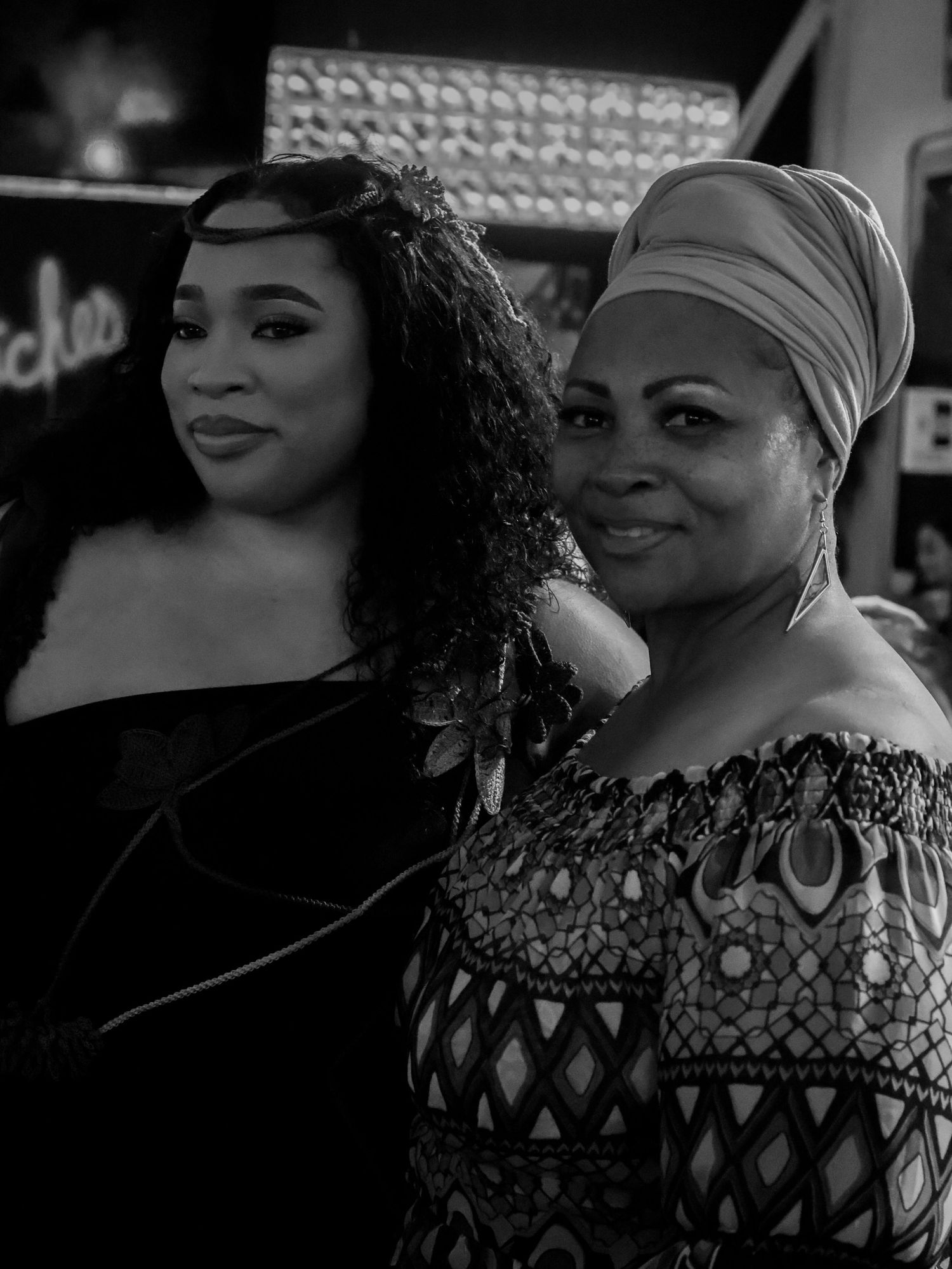 Black and white portrait of people in elegant attire and decorative patterns.