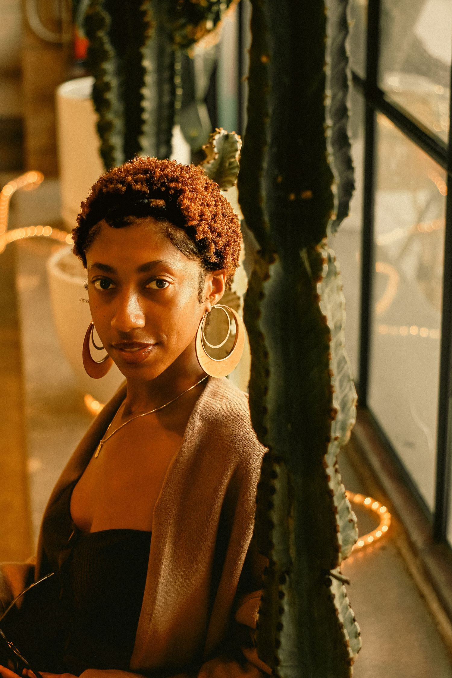 Warm-toned portrait with string lights and natural expressions creating cozy atmosphere.
